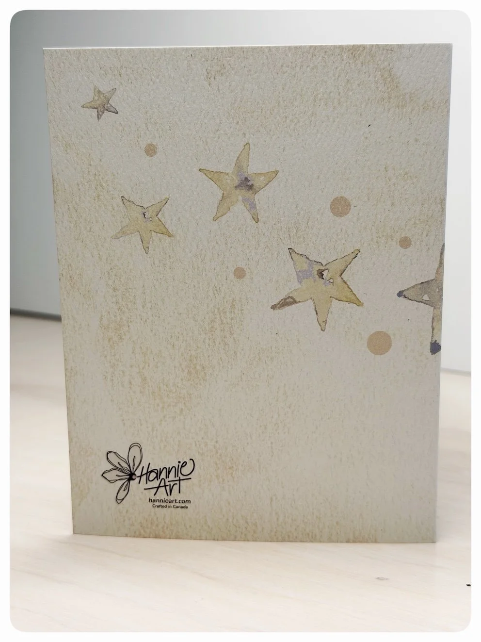 Back of baby boy romper greeting card with soft watercolour stars and Hannie Art logo