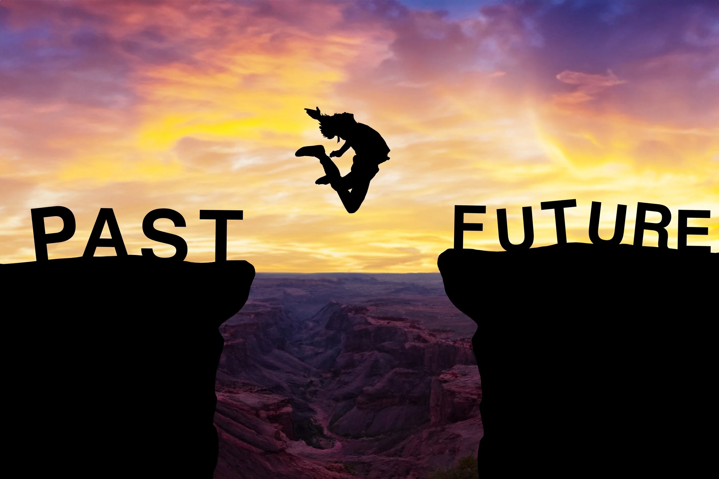 A silhouette of a person jumping from a cliff labeled 'Past' to another cliff labeled 'Future' during a colorful sunset over a canyon.