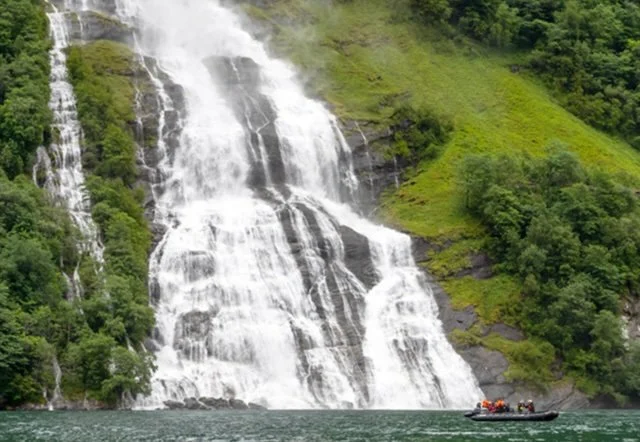 Zodiac and passengers at a waterfall