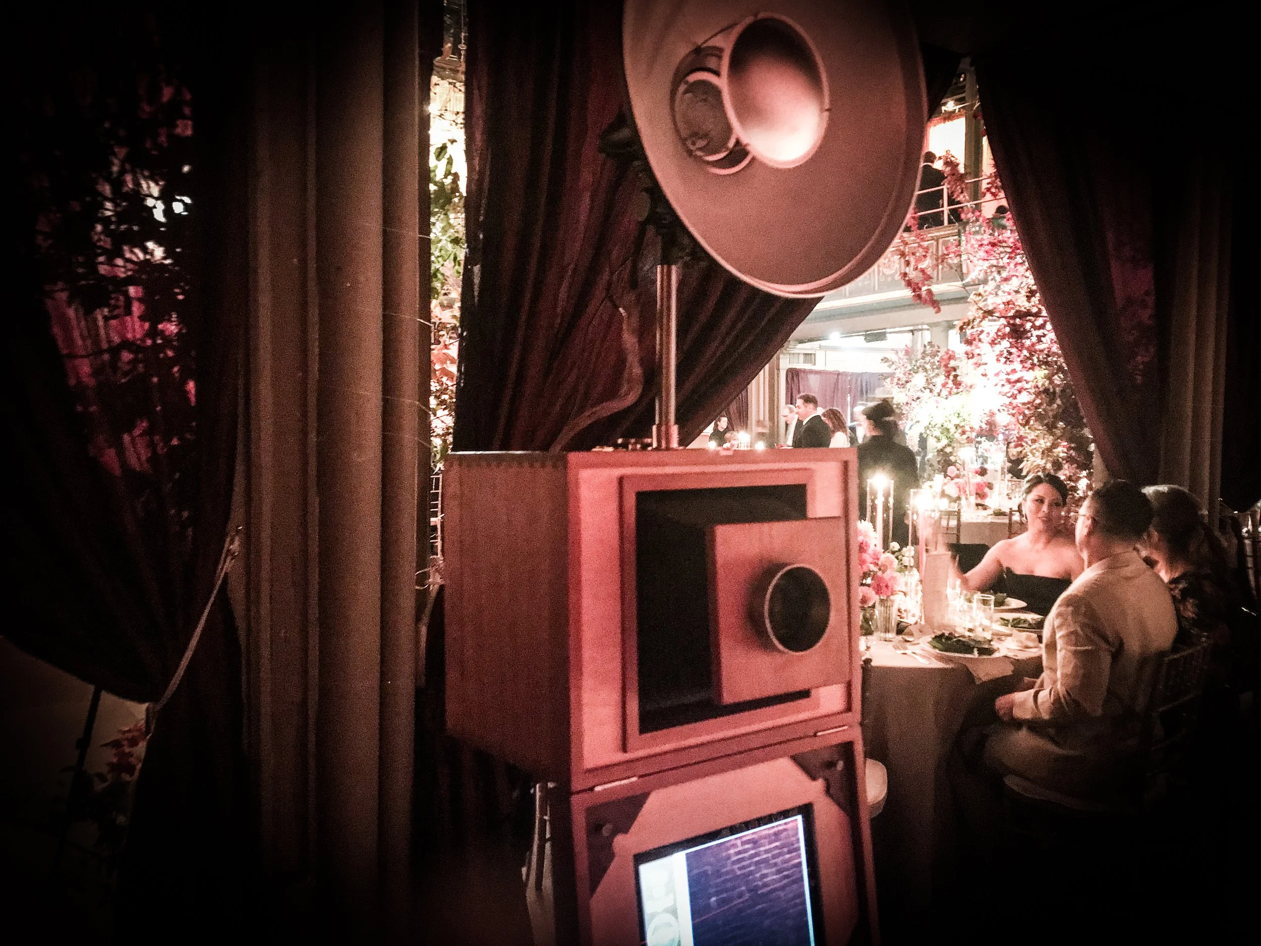 event guests dining near photo booth setup with vintage camera equipment