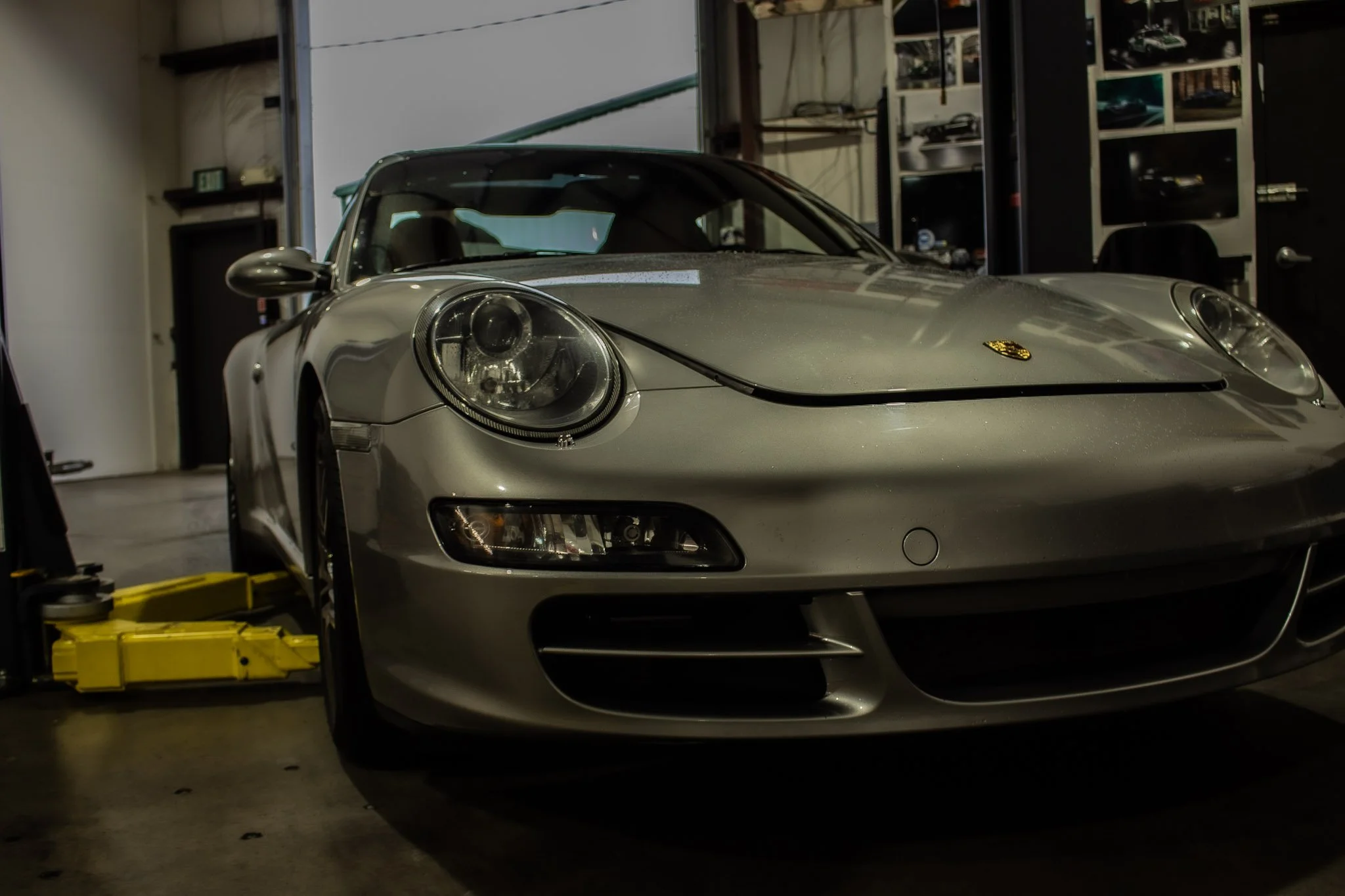 Front view of a silver Porsche Targa sports car inside a garage.