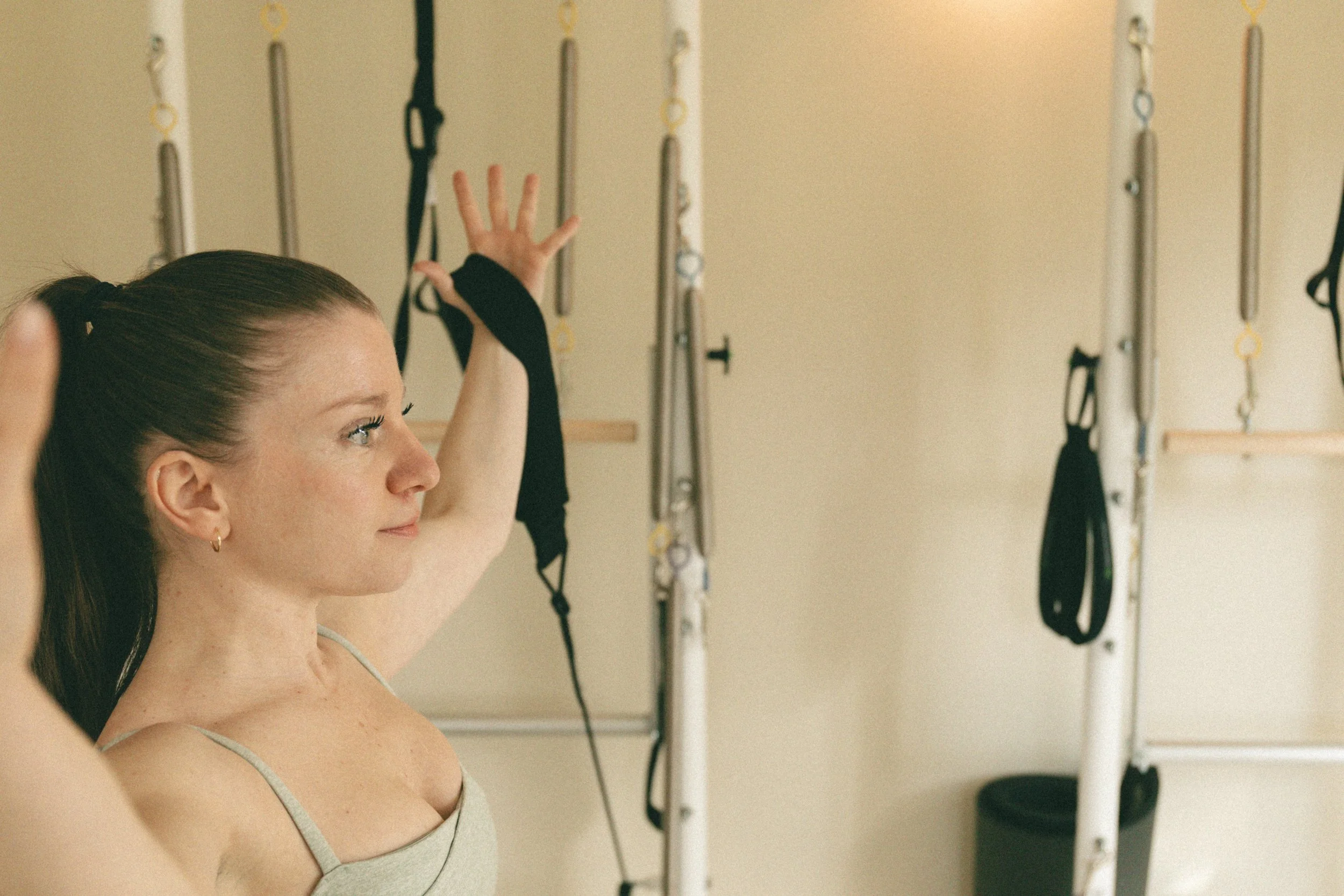 Bérangère Iaquinta en train de muscler ses bras dans son studio de pilates 6ème Sens sur un reformer Balanced Body