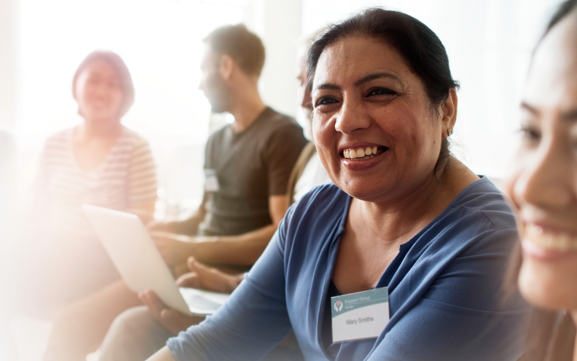 Three women sitting together in a room, one woman speaking with a serious expression, while the others listen.