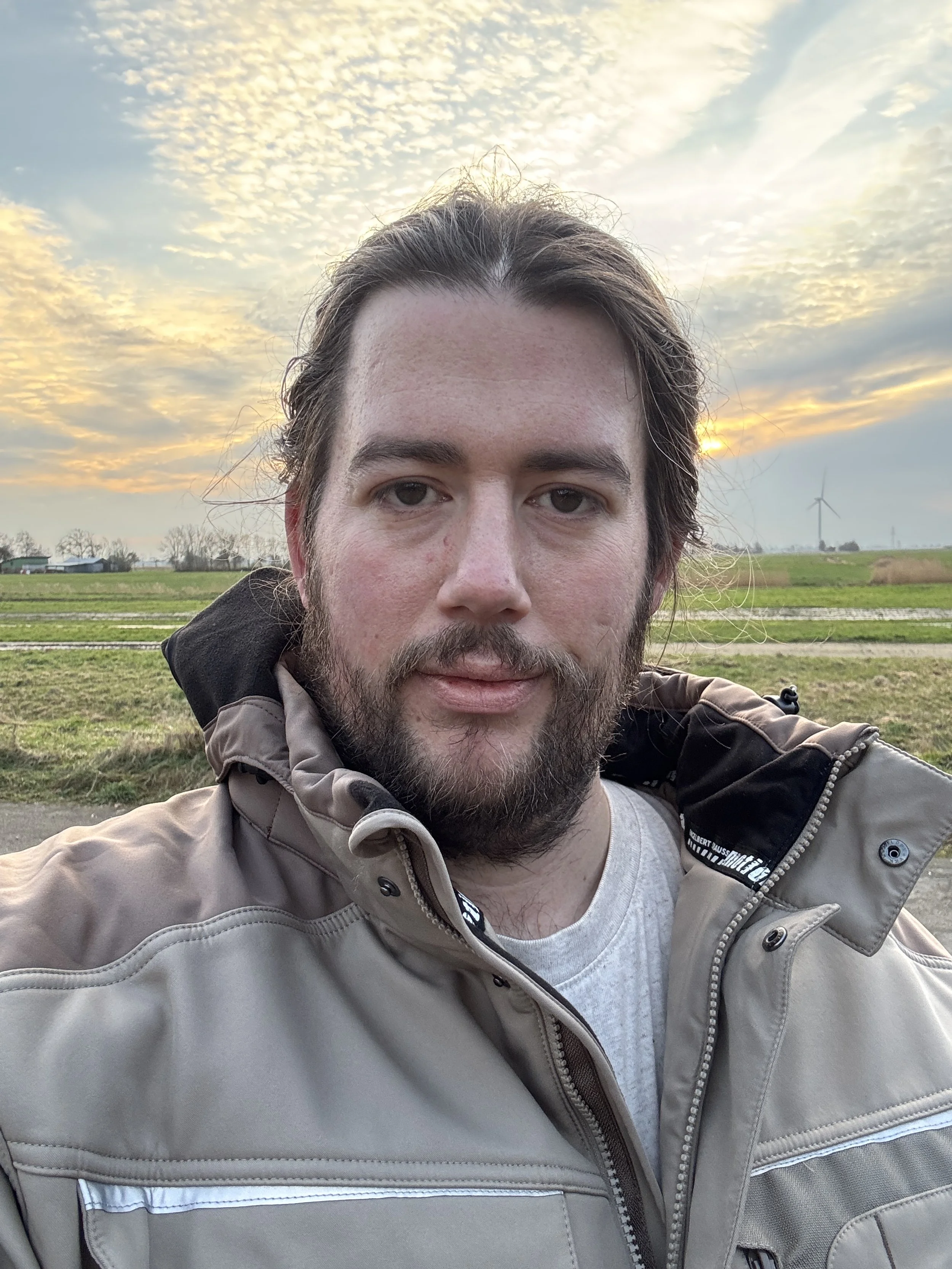 Sven, der Autor von equilibrium, in einem geerdeten Porträt unter freiem Himmel. Das Bild zeigt ihn in Arbeitskleidung vor einer ländlichen Kulisse und symbolisiert den Aufbruch in ein bewusstes, verwirklichtes Leben 2026.