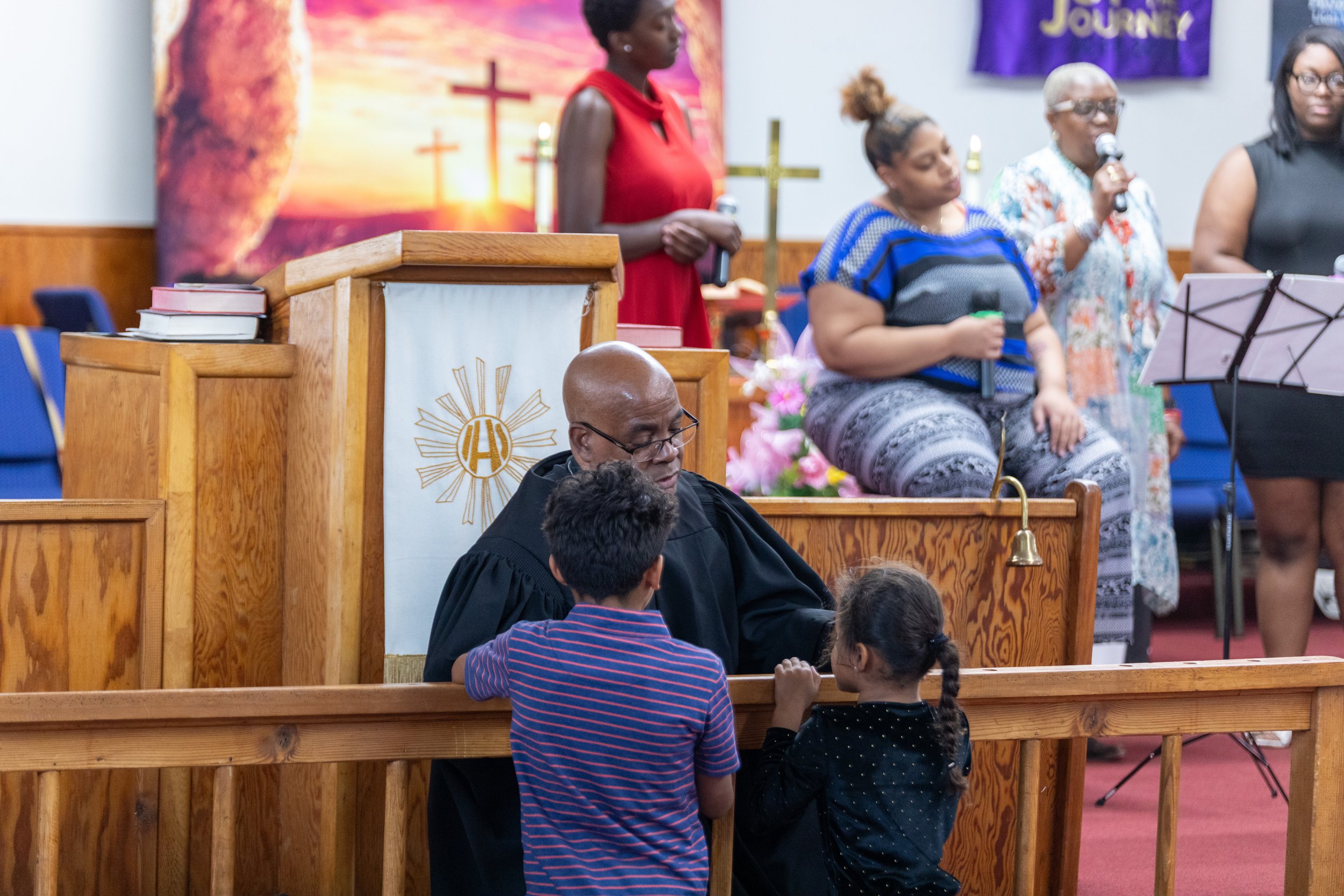 Pastor praying over children at the altar at Visionary Hollowell Community United Methodist Church in Midland, Texas
