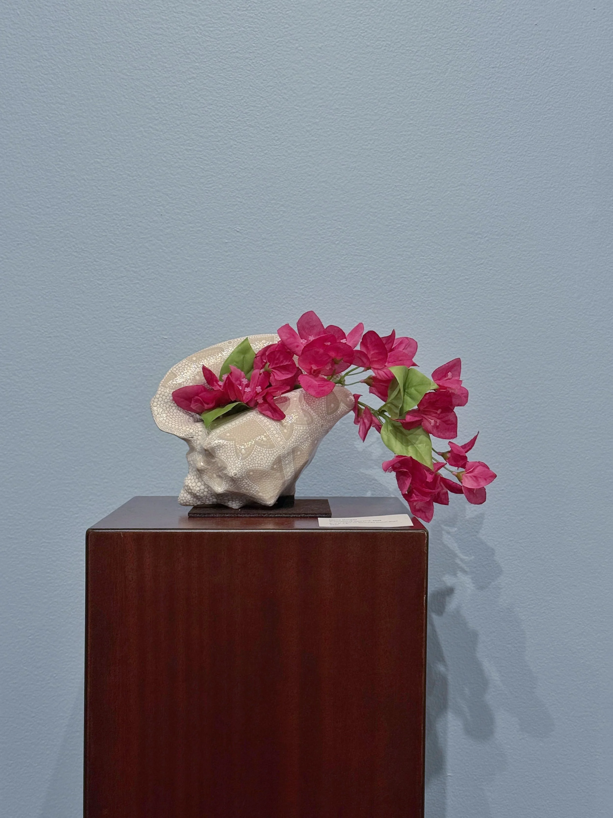 Breeze Block Remains, 2025
Acrylic paint on bleached conch shell 
6&rdquo; W x 4&rdquo;D x 8&rdquo;H

Breeze Block Remains mimics the pattern of the blocks that lined my grandmothers front yard and draws a connection between architectural openings an