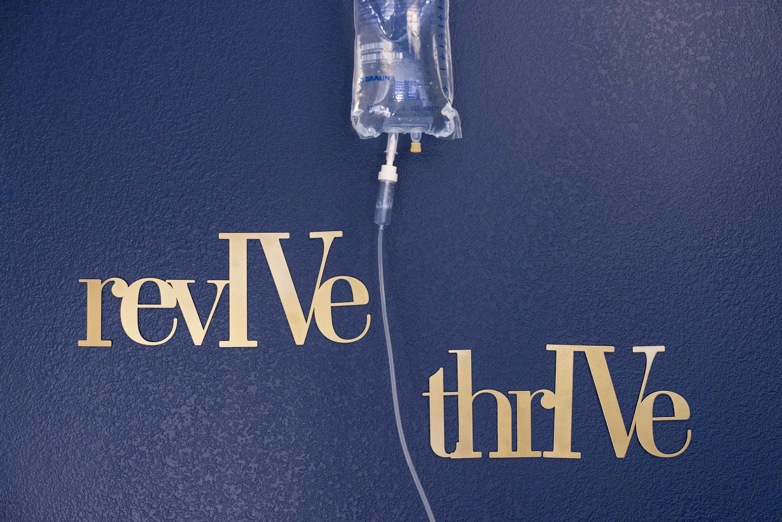 Navy blue wall with gold words saying Revive & Thrive