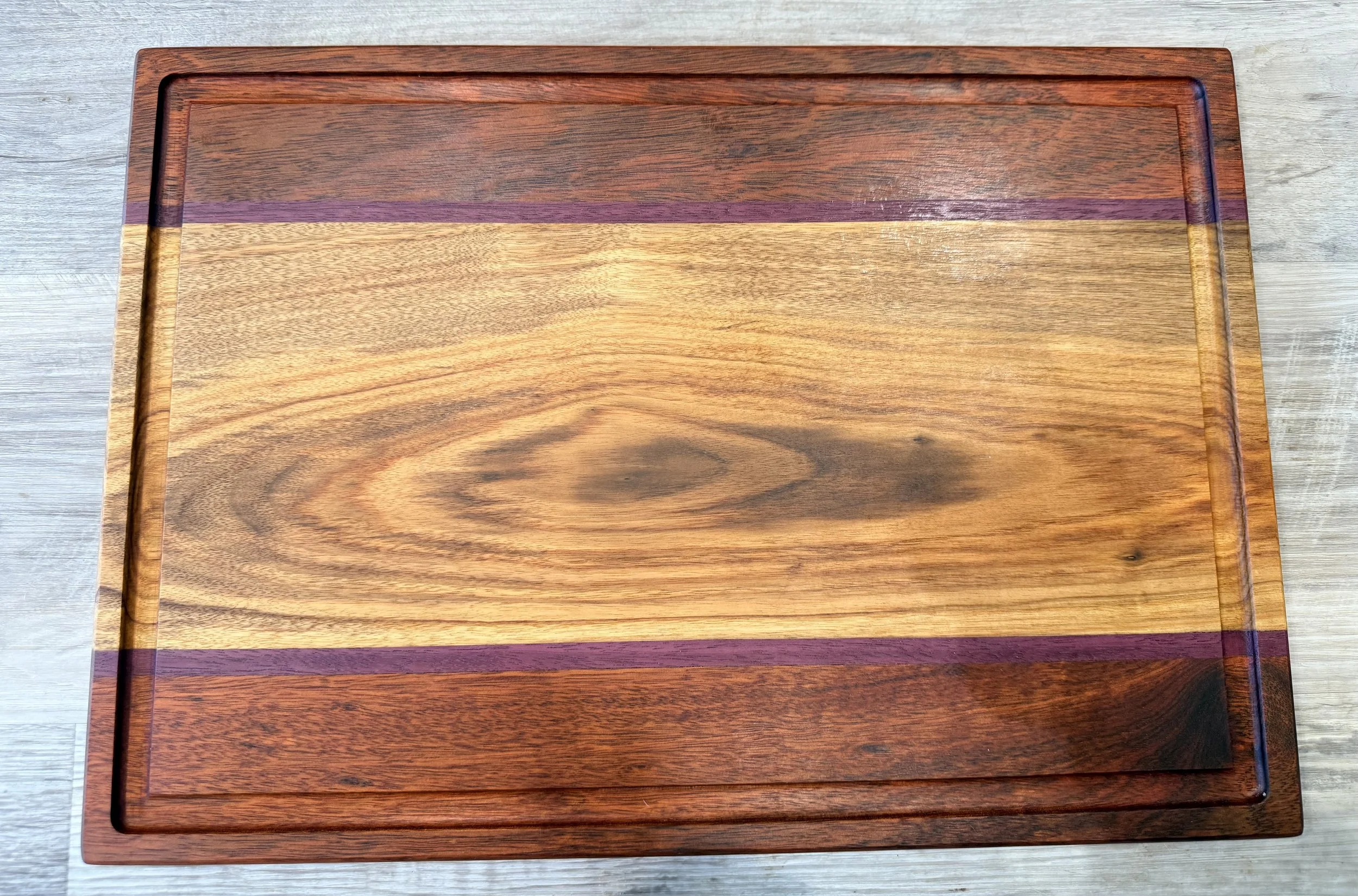 Product #: 022601
18 1/4" x 12 3/4" x 3/4" Bloodwood, canary wood, and purple heart cutting board w/ juice groove
$120
