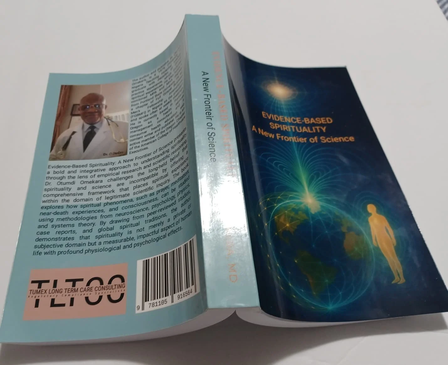 Front and back cover of a book titled 'Evidence-Based Spirituality: A New Frontier of Science', with a digital illustration of a human figure surrounded by a glowing, interconnected web of energy over a world map background on the front cover. The back cover features a photo of a man in a white coat, sitting in a room, with a summary of the book's content.