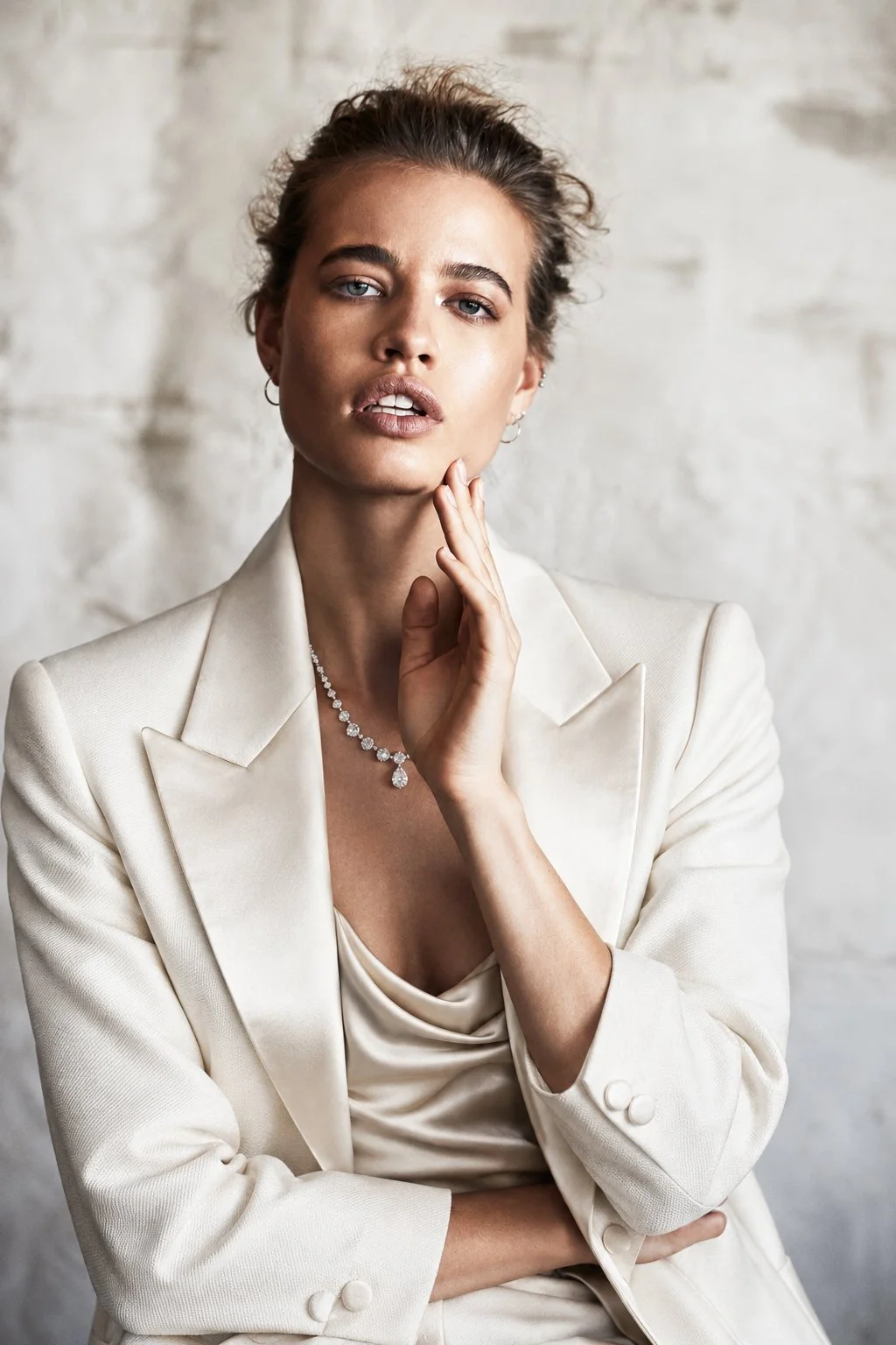 Portrait in a white suit with a hand at the neck