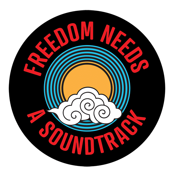 Circular logo with a black background, featuring a yellow sun behind white clouds, surrounded by multicolored concentric circles, with red text around the edge that reads "FREEDOM NEEDS A SOUNDTRACK."