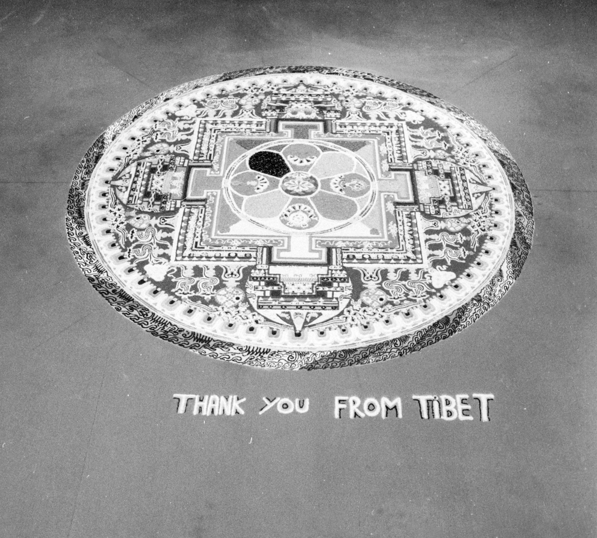 Floor mandala art from Tibet with intricate patterns and symbols, and text below that reads 'Thank you from Tibet'.
