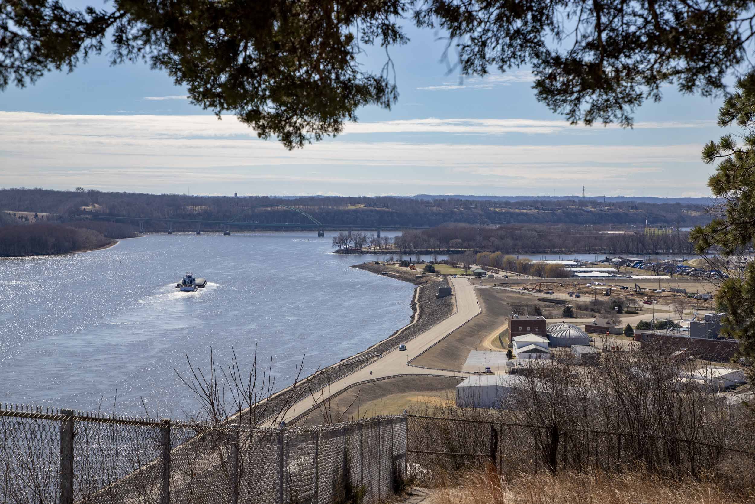 Cargo ship sailing on a river approaching a bridge