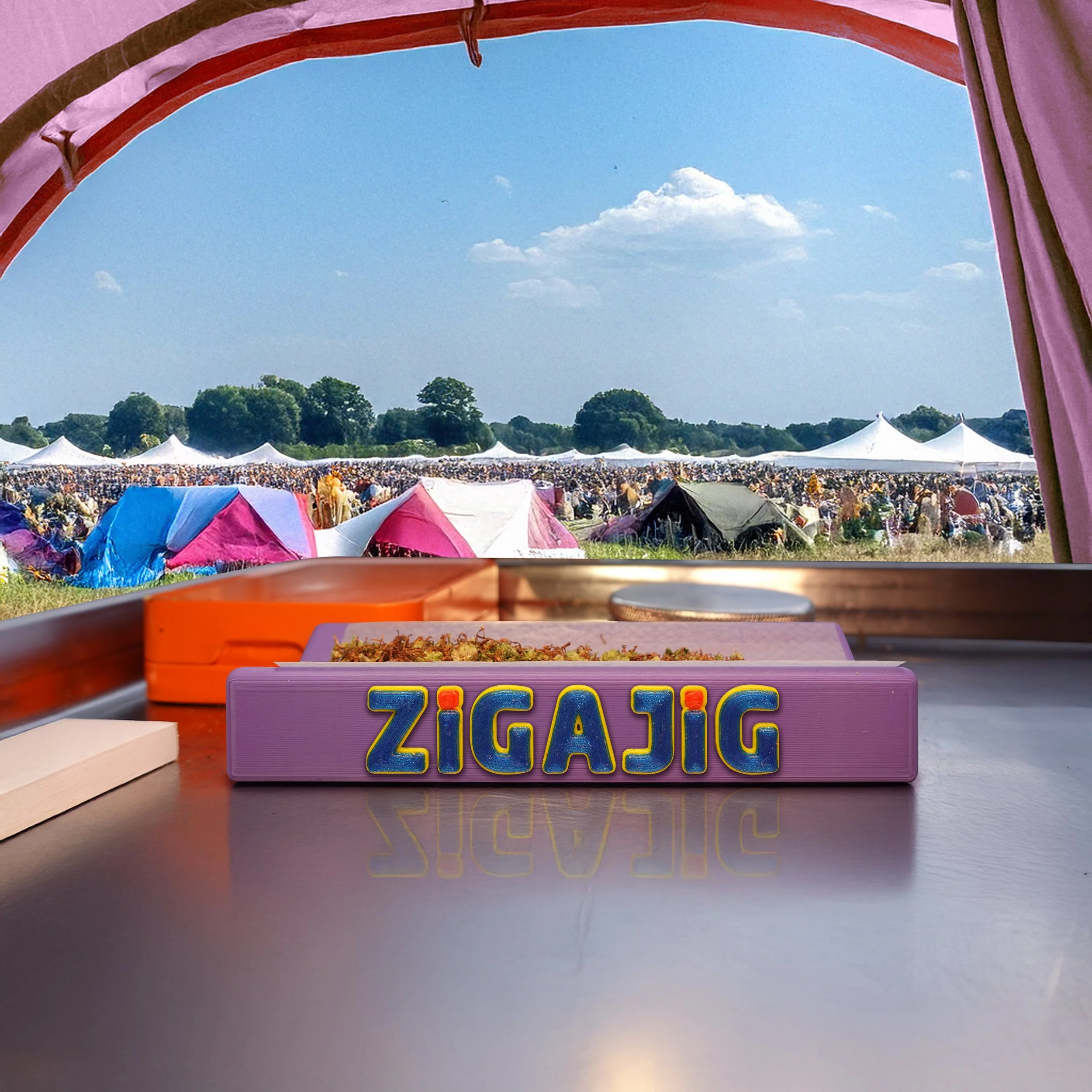 View from inside a tent at a festival showing a field of colorful tents, with the a  ZigaJig King Slim Rolling Rack on a tray in the foreground and blue sky with some clouds.