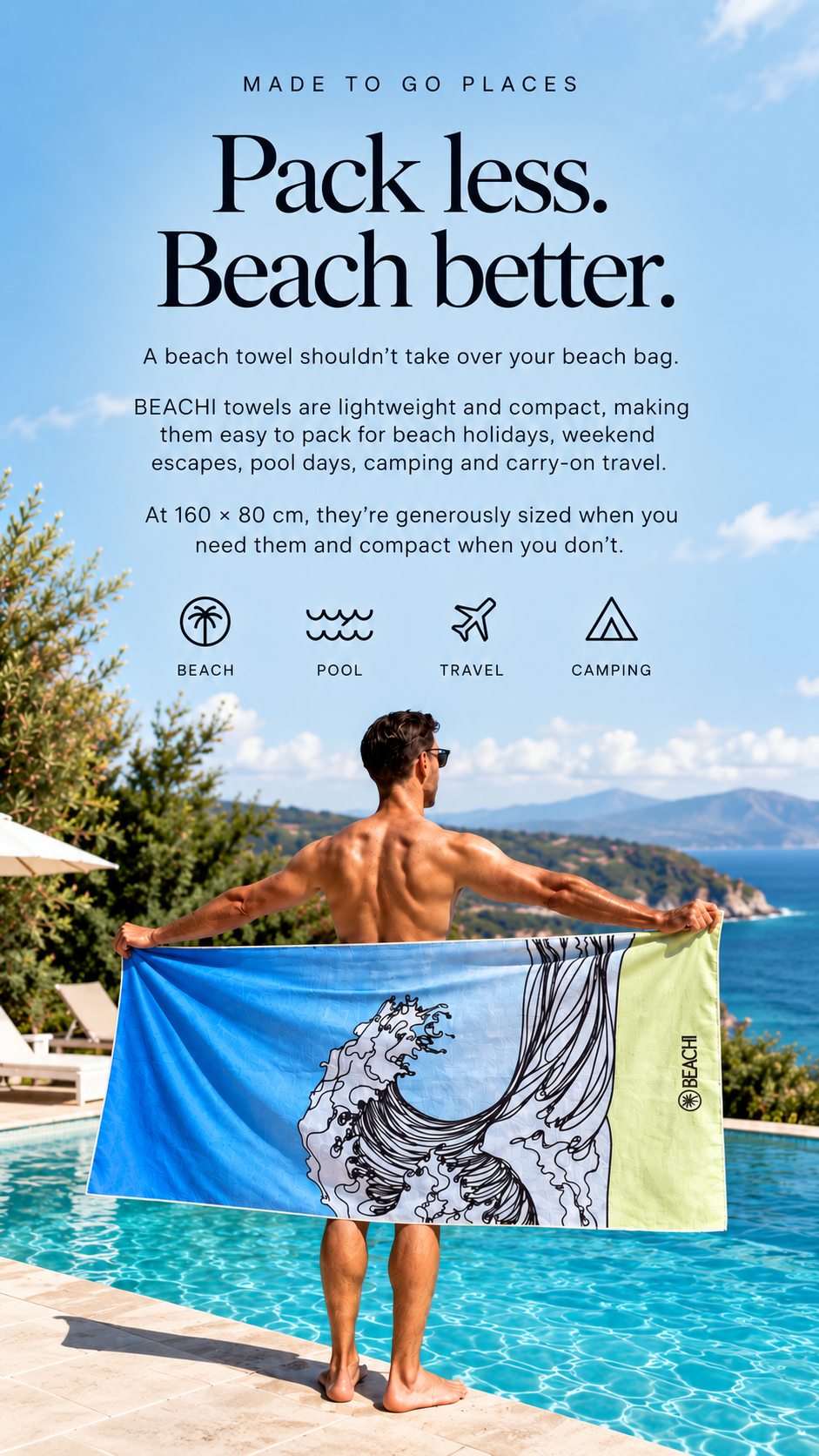 A man holding a large beach towel with ocean waves design, standing by a pool on a sunny day with mountains in the background.