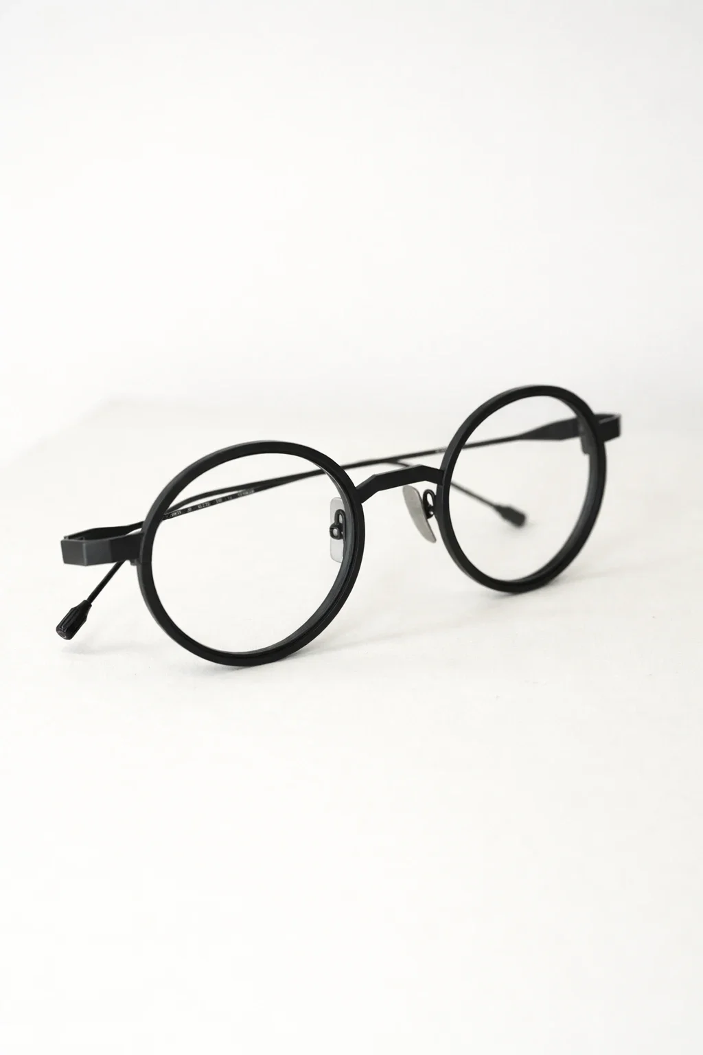 Černé titanové brýle Clément Lunetier s minimalistickým tvarem, tenkými zorníky a čistými liniemi na bílém pozadí.