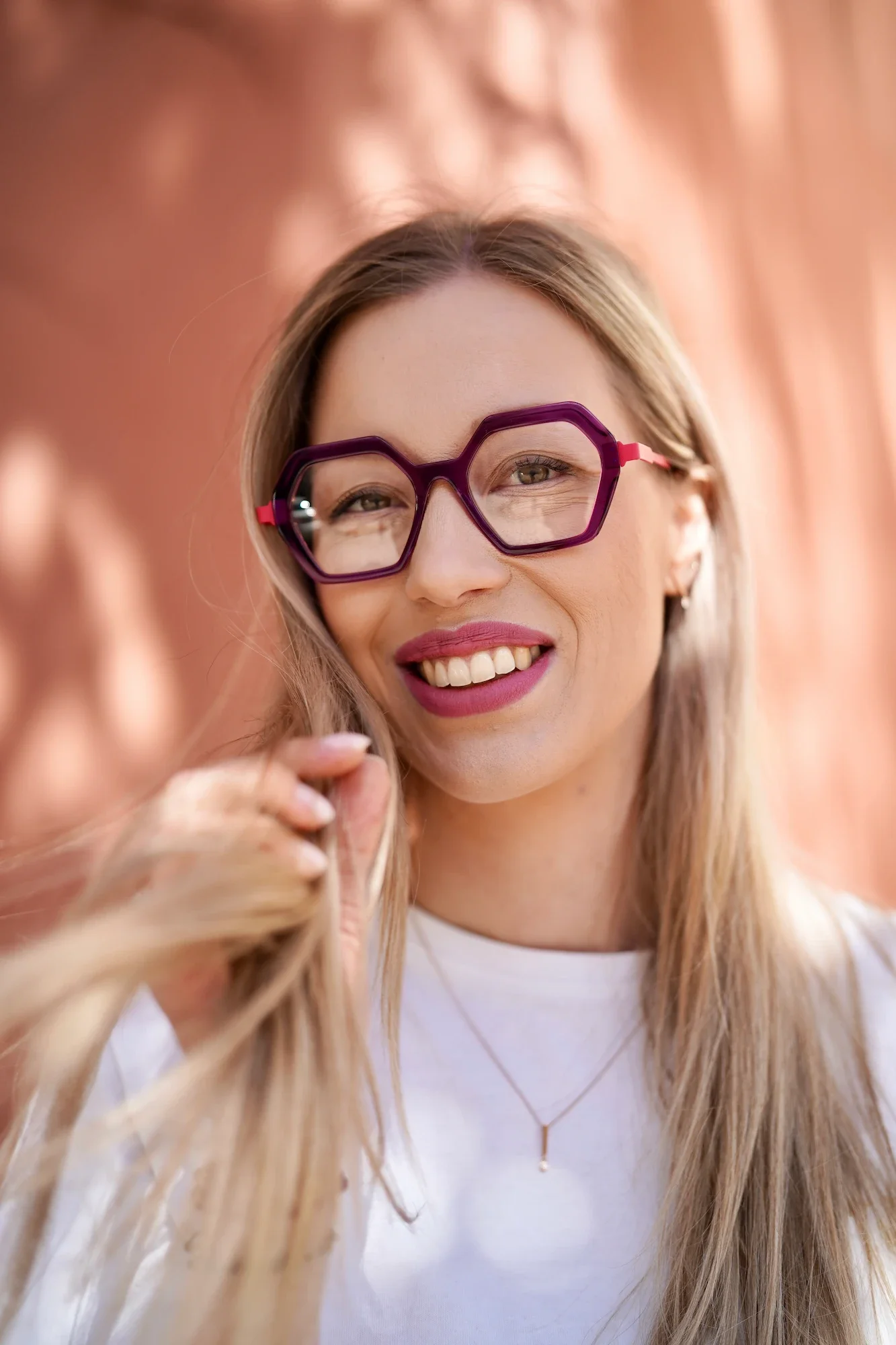 Detailní portrét usmívající se ženy s výraznými fialovými brýlemi značky La Brique et la Violette z kurátorského výběru oční optiky Vidím Pěkně v Praze 6.