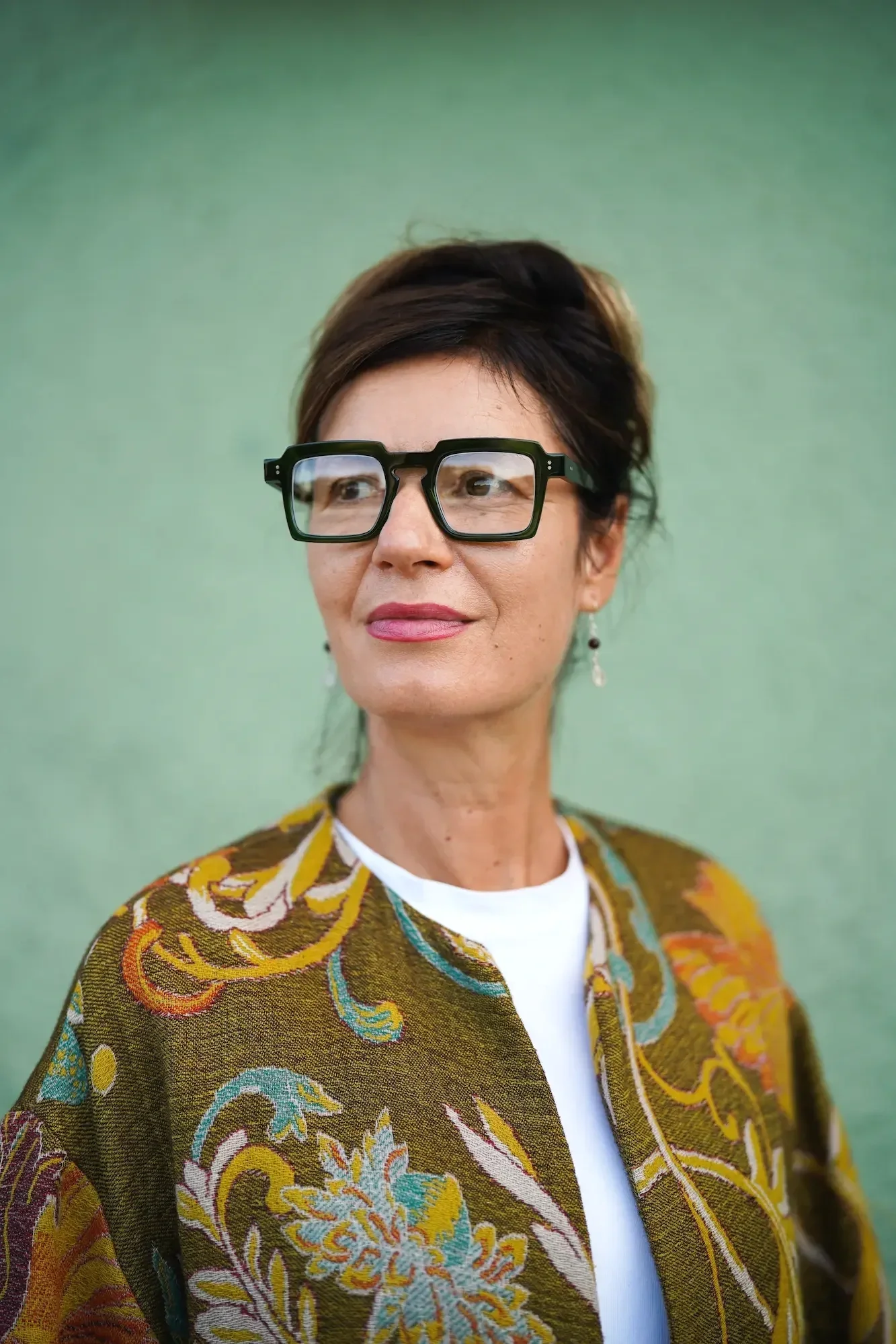 Žena v zelených brýlích Anne et Valentin před optikou Vidím Pěkně v Praze 6 – Střešovicích