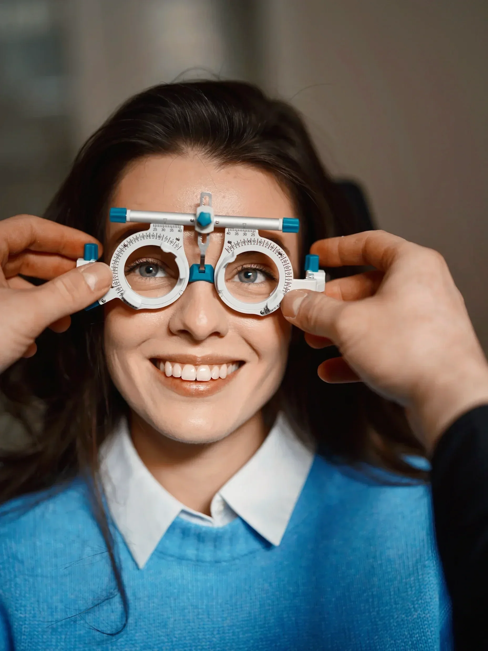 Uvolněná klientka při přesném měření zraku pomocí zkušební obruby. Odborná optometrie a osobní přístup v oční ambulanci Vidím Pěkně v pražských Střešovicích.