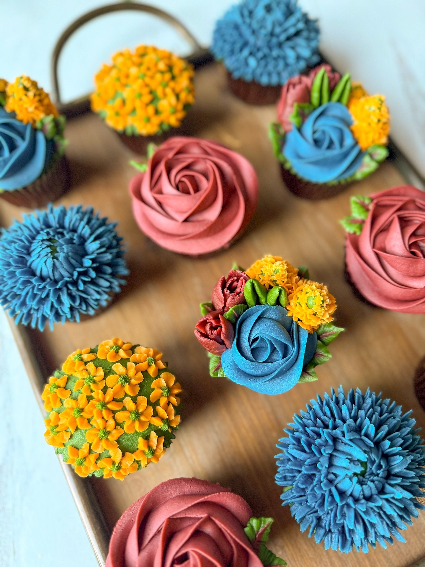 💍 Bridal shower blooms, but make them cupcakes!

These floral beauties were custom-designed for a Sunday bridal shower and included an elegant mix of rust roses, royal blue chrysanthemums, apricot blossoms, and lush greenery. All buttercream. All ed