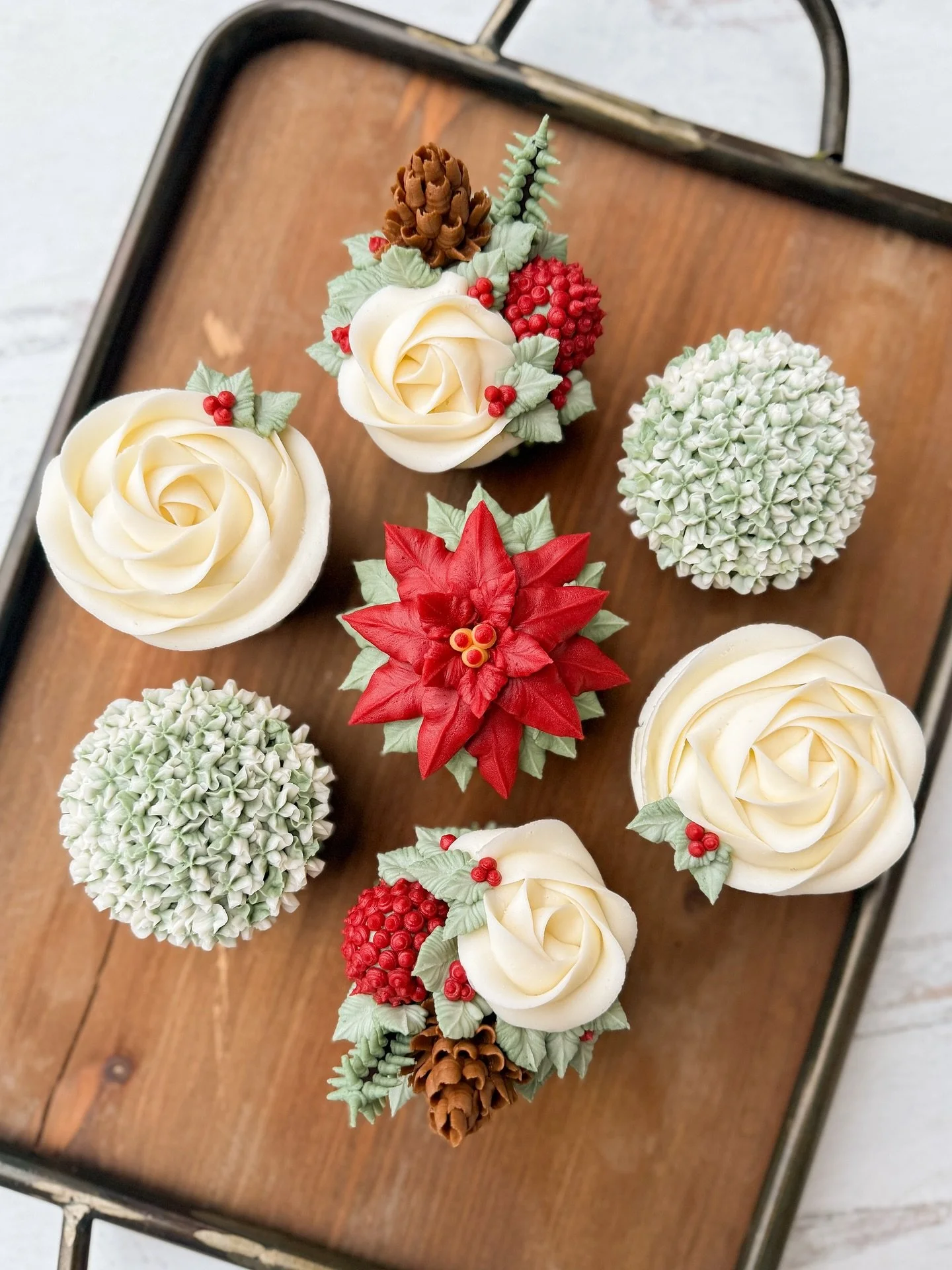 Holiday blooms in buttercream form!🎄

This festive set features bright red poinsettias, snowy white roses, winter greenery, pine cones, and the sweetest little berries &mdash; all hand-piped one petal at a time. It&rsquo;s cozy, elegant, and everyth