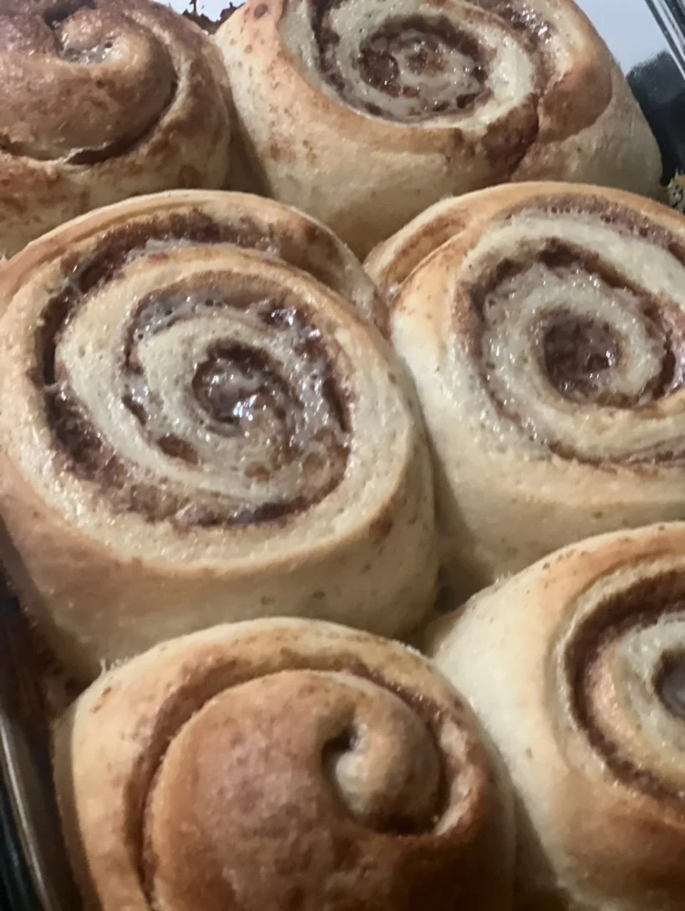 Close-up of several cinnamon rolls with swirled cinnamon filling.