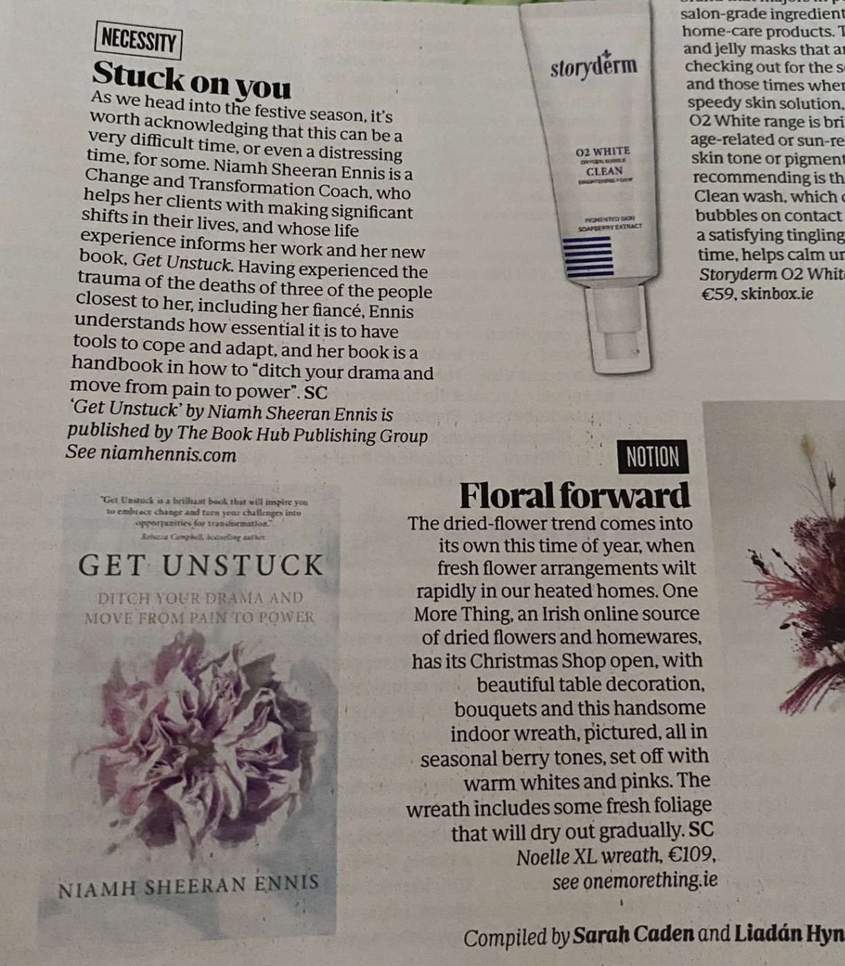 A newspaper page featuring book and product advertisements. One ad promotes Niamh Sheeran Ennis's book 'Get Unstuck,' with an image of the book cover showing a purple flower. Another ad shows a tube of Storyderm O2 White skincare product. The page includes headings, text, and a quote about the book.