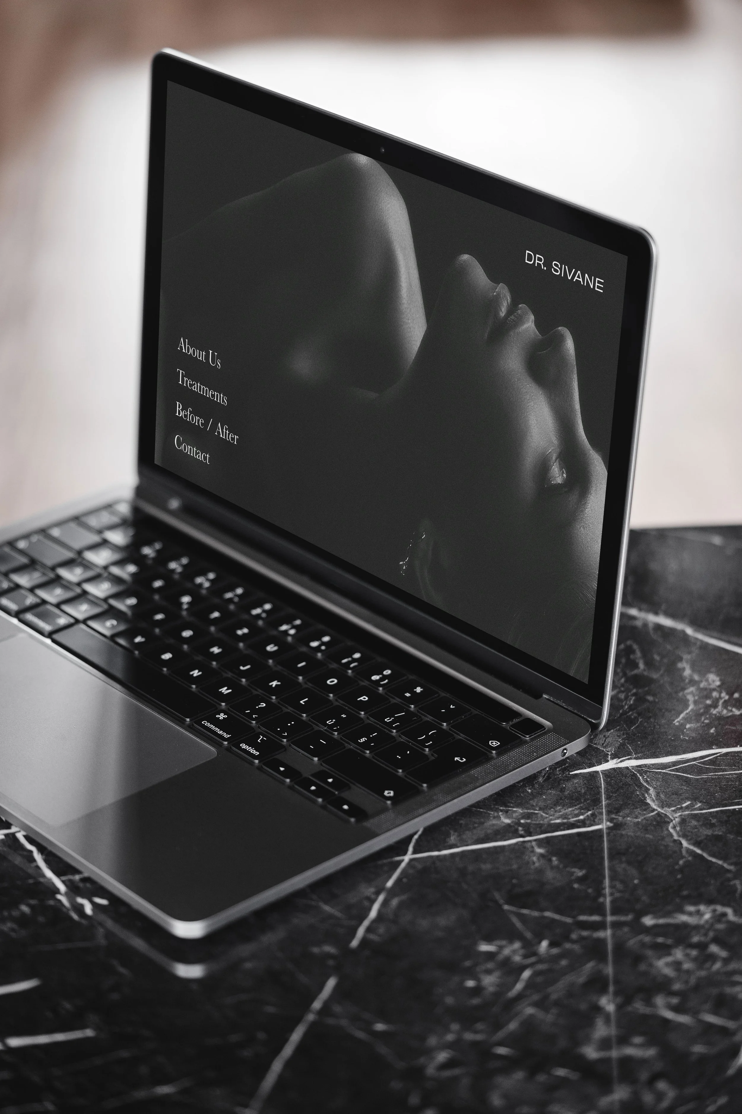 The desktop design uses a restrained black-and-white palette. Large, editorial-style imagery paired with modern serif typography conveys sophistication.