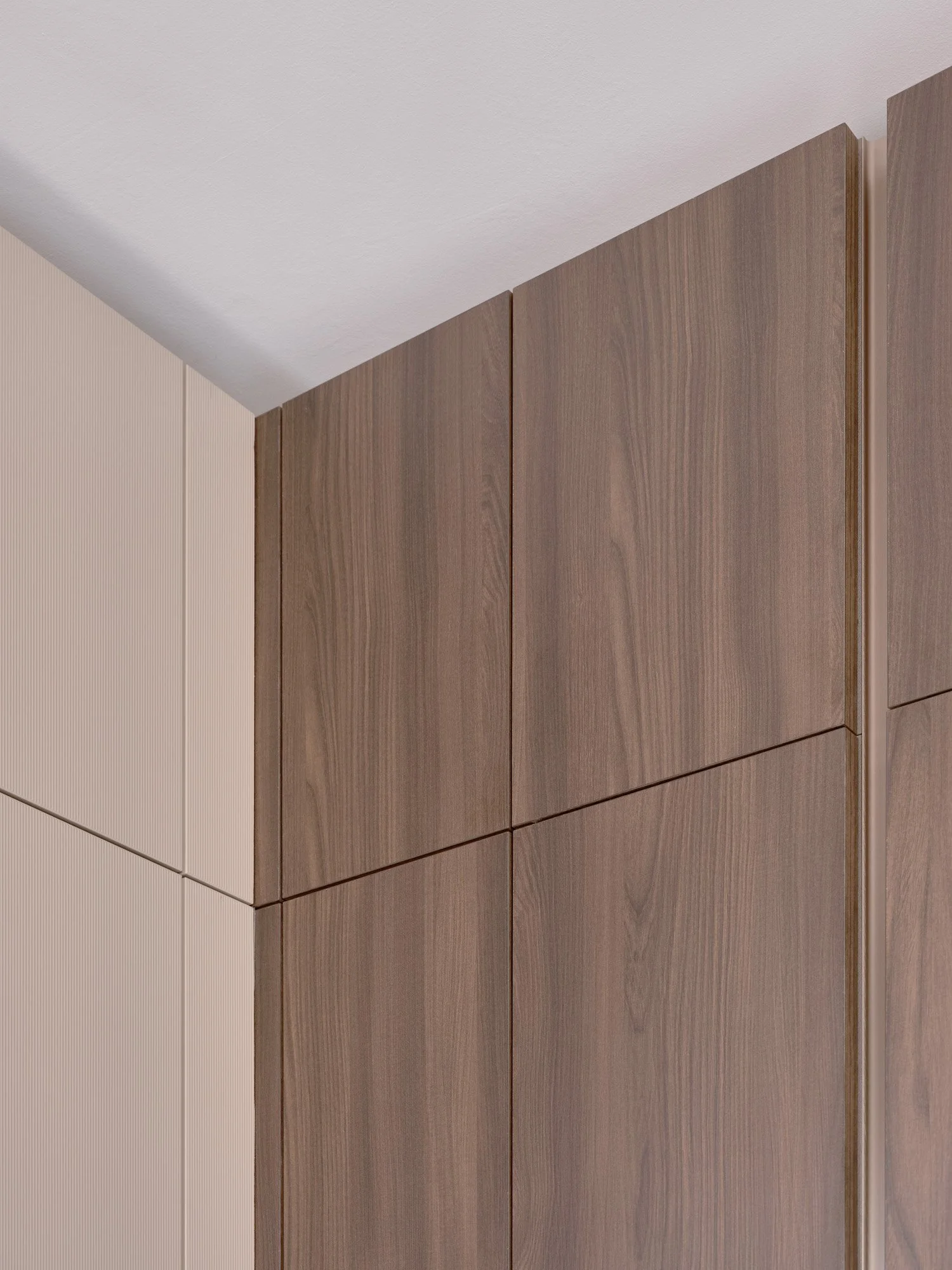 Particolare di un armadio in legno scuro e una parete beige con finitura a righe verticali.