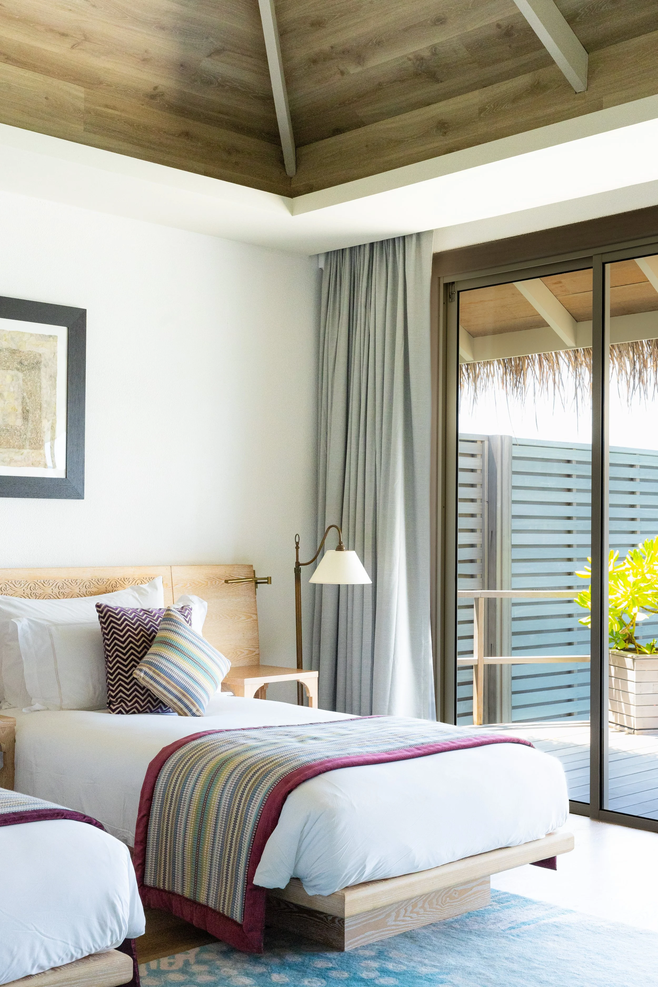 Hell eingerichtetes Kinderzimmer mit Terrasse, Holzelementen und Holz-Decke.