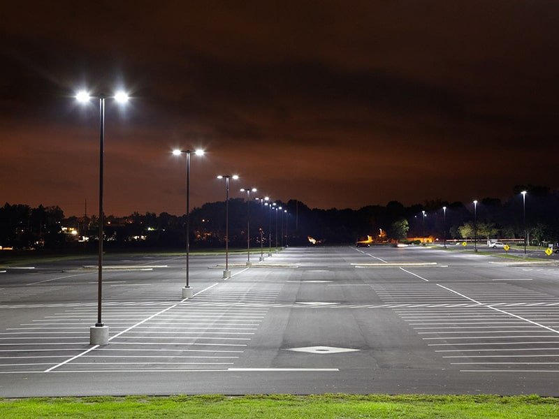 Empty parking lot that has recently had sealcoating and line striping done.