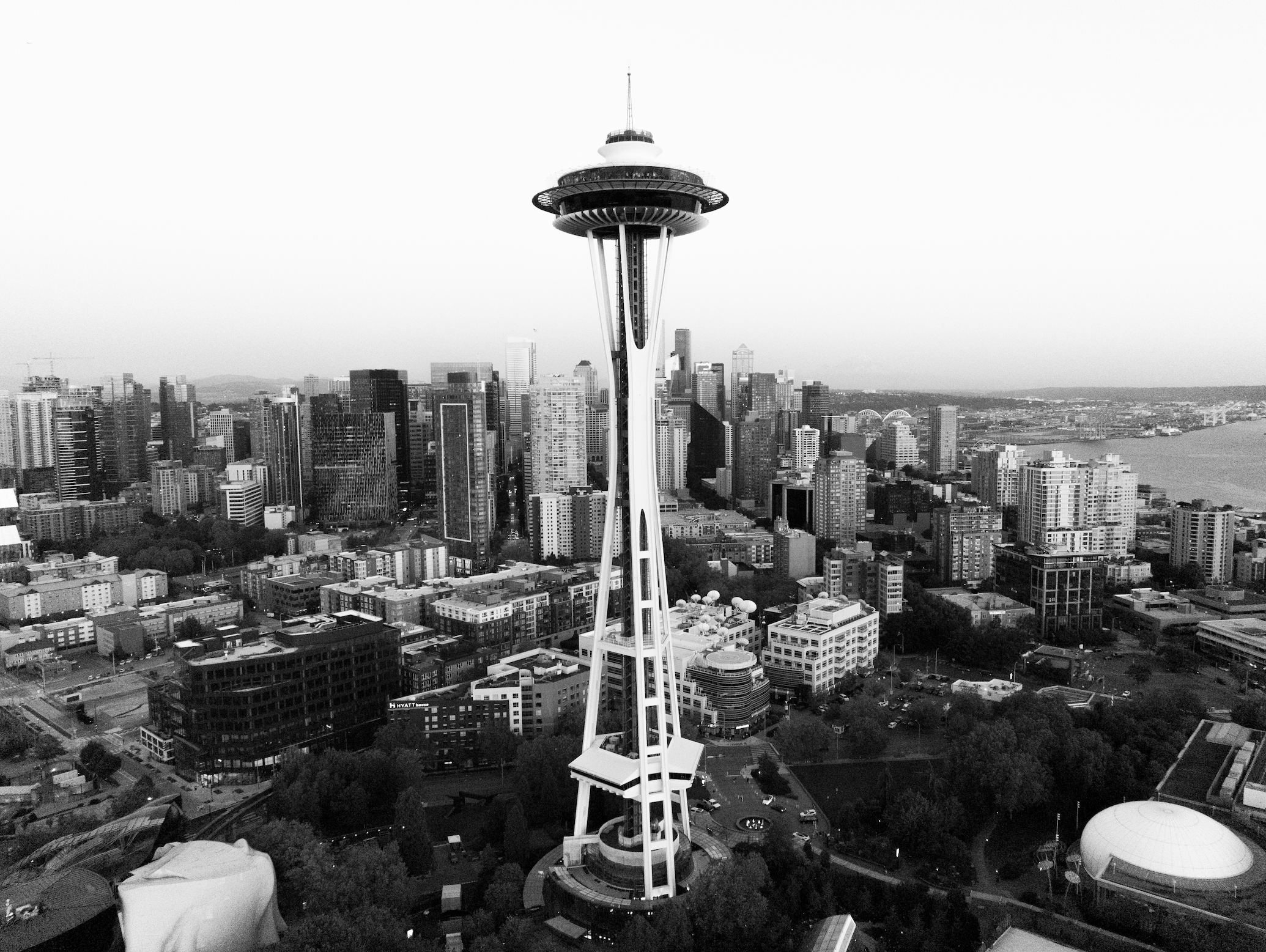 A black and white aerial view of Seattle, Washington, showing the Space Needle and the city's skyline along the waterfront.