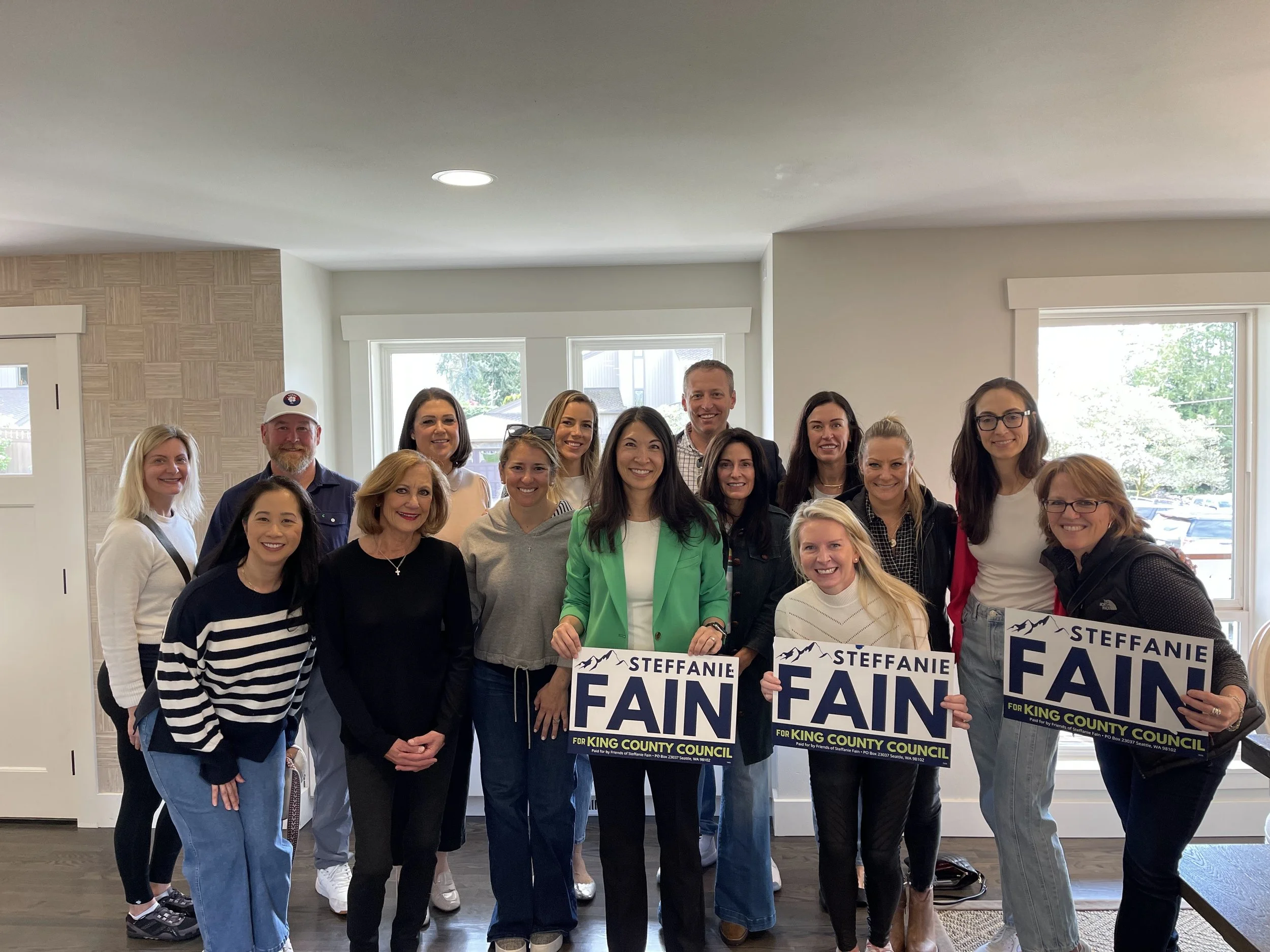 Group of people holding campaign signs for Steffanie Fain running for King County Council.