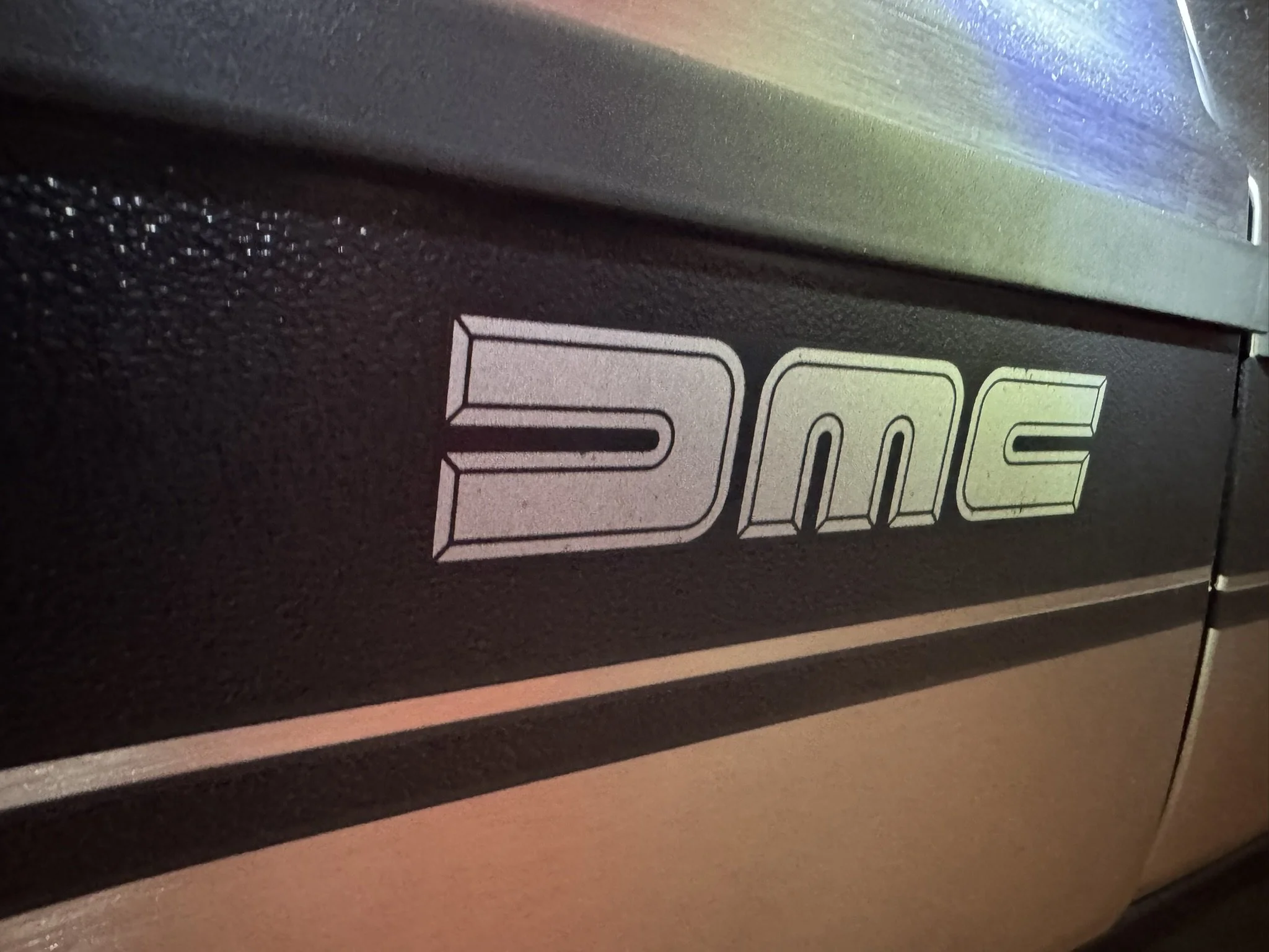 The graphics down the side are original dealer-installed vinyl pieces as the DMC logo is printed on. Replica vinyl has the logo cut-out, so the steel fender shows through. 