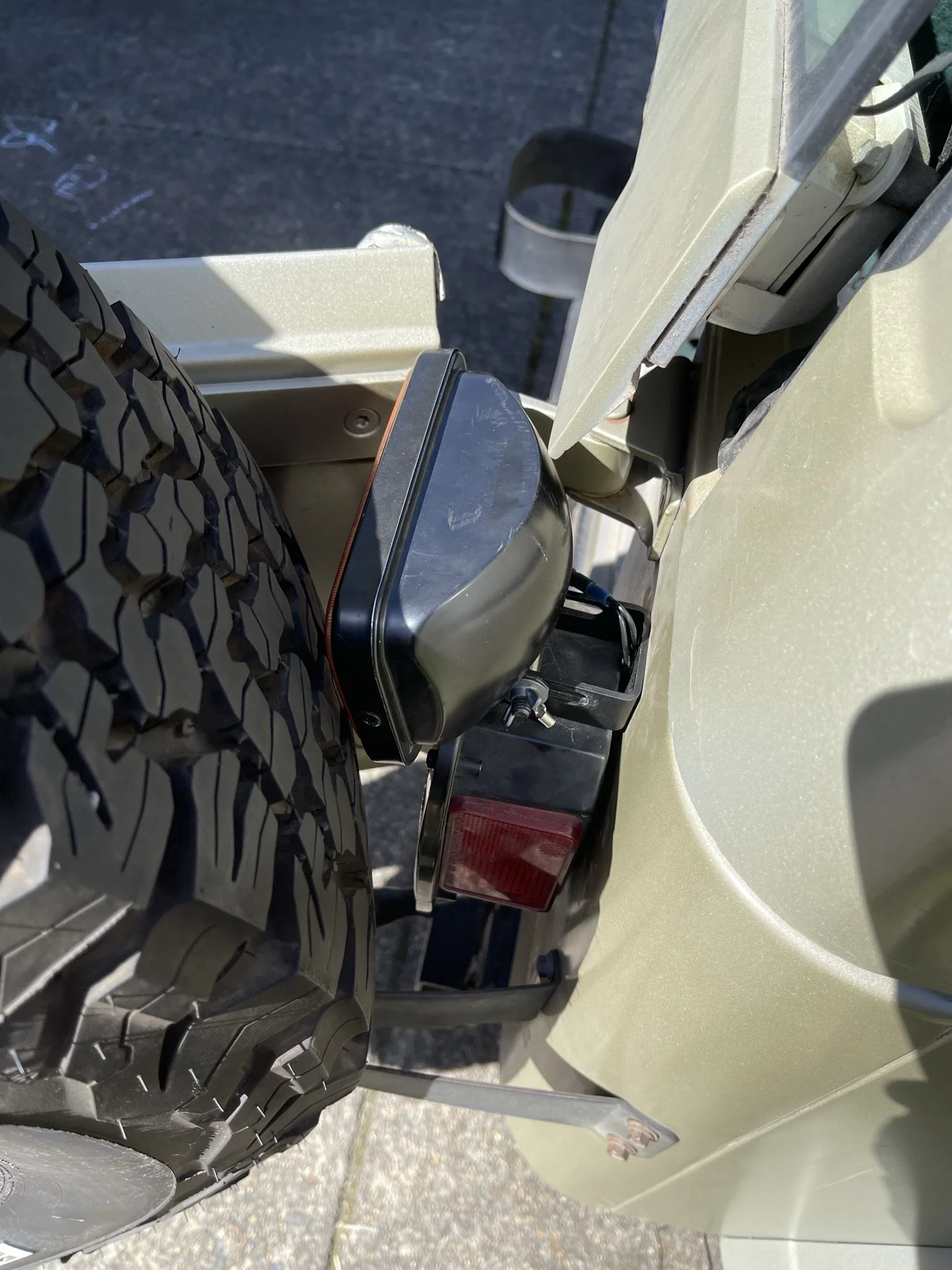 The tool-free design allows for a quick one-handed loosening, then the light slides backward in a slot and folds down, giving clearance for the hard top to open. 