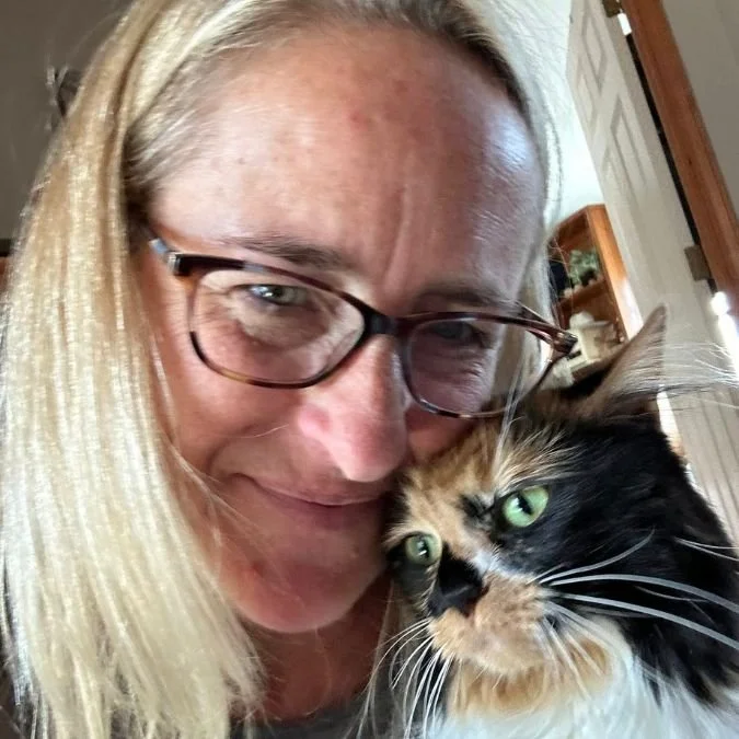 Jacklyn Rusnock cuddling her adopted calico cat indoors, capturing the quiet bond between a rescue cat and her human