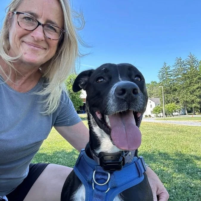 Jacklyn Rusnock smiling beside her adopted dog during a walk in the neighborhood