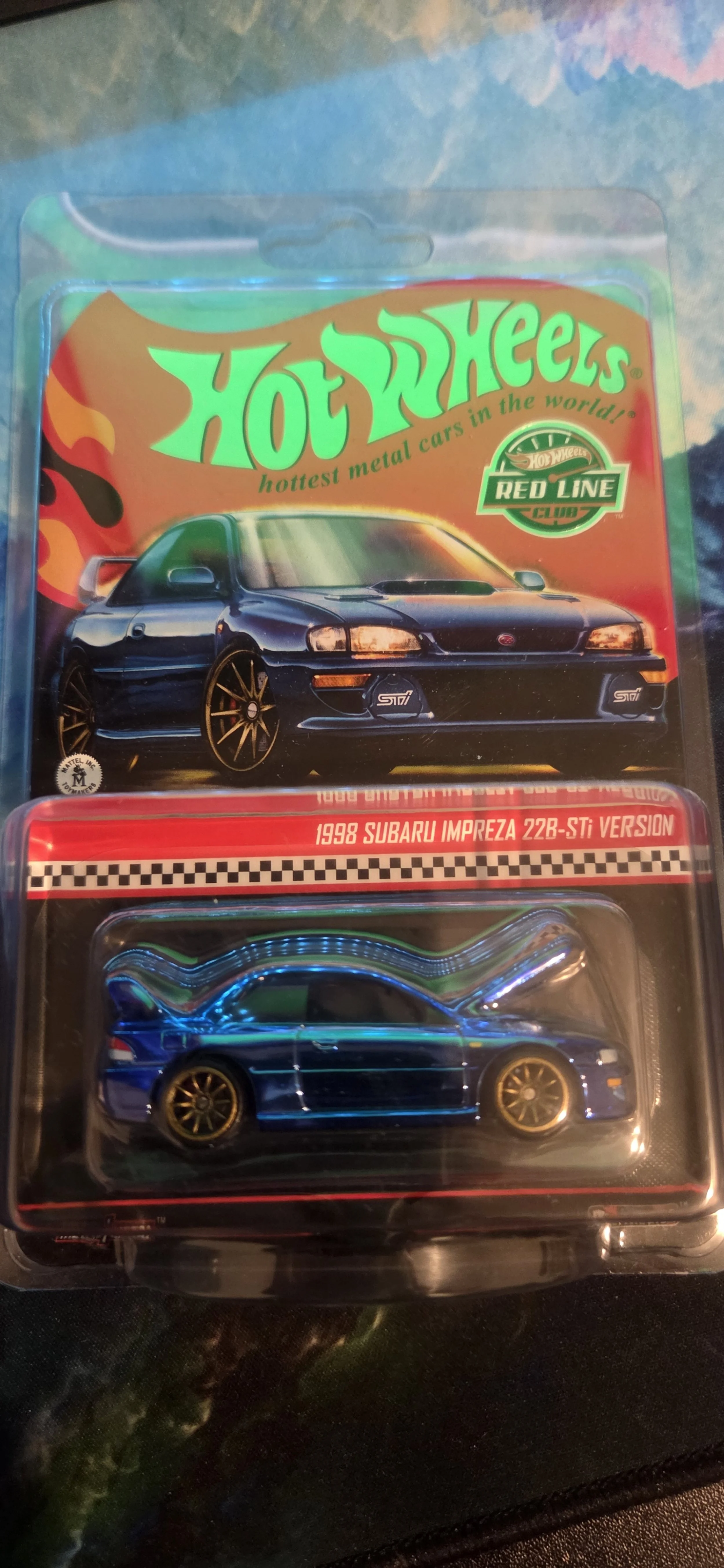 Hot Wheels toy car in packaging featuring a 1998 Subaru Impreza 22B-STi model with a blue body and gold wheels.