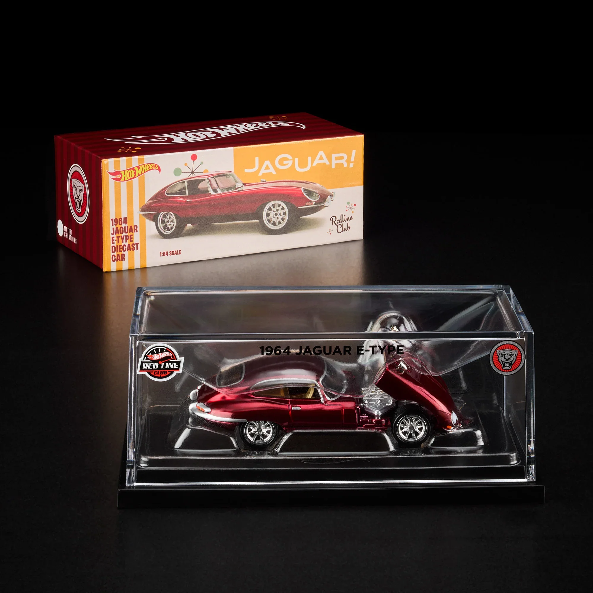 Scale model of a 1964 Jaguar E-Type car in red, inside a clear plastic display case with black base, placed in front of a Redline Club box featuring an image of the actual car.