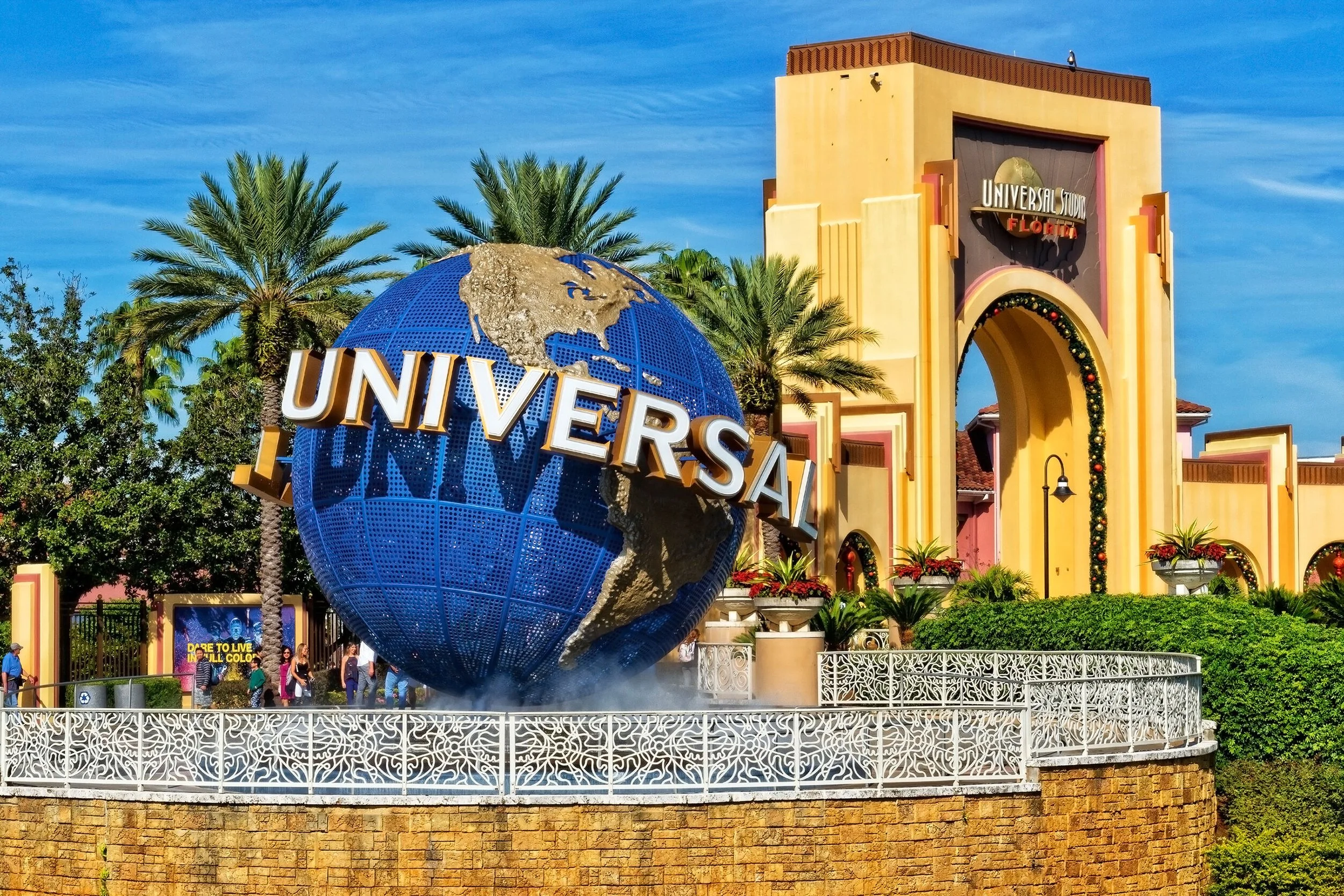 Universal Studios Florida entrance with a large globe sculpture featuring the word 'Universal' and palm trees around it.
