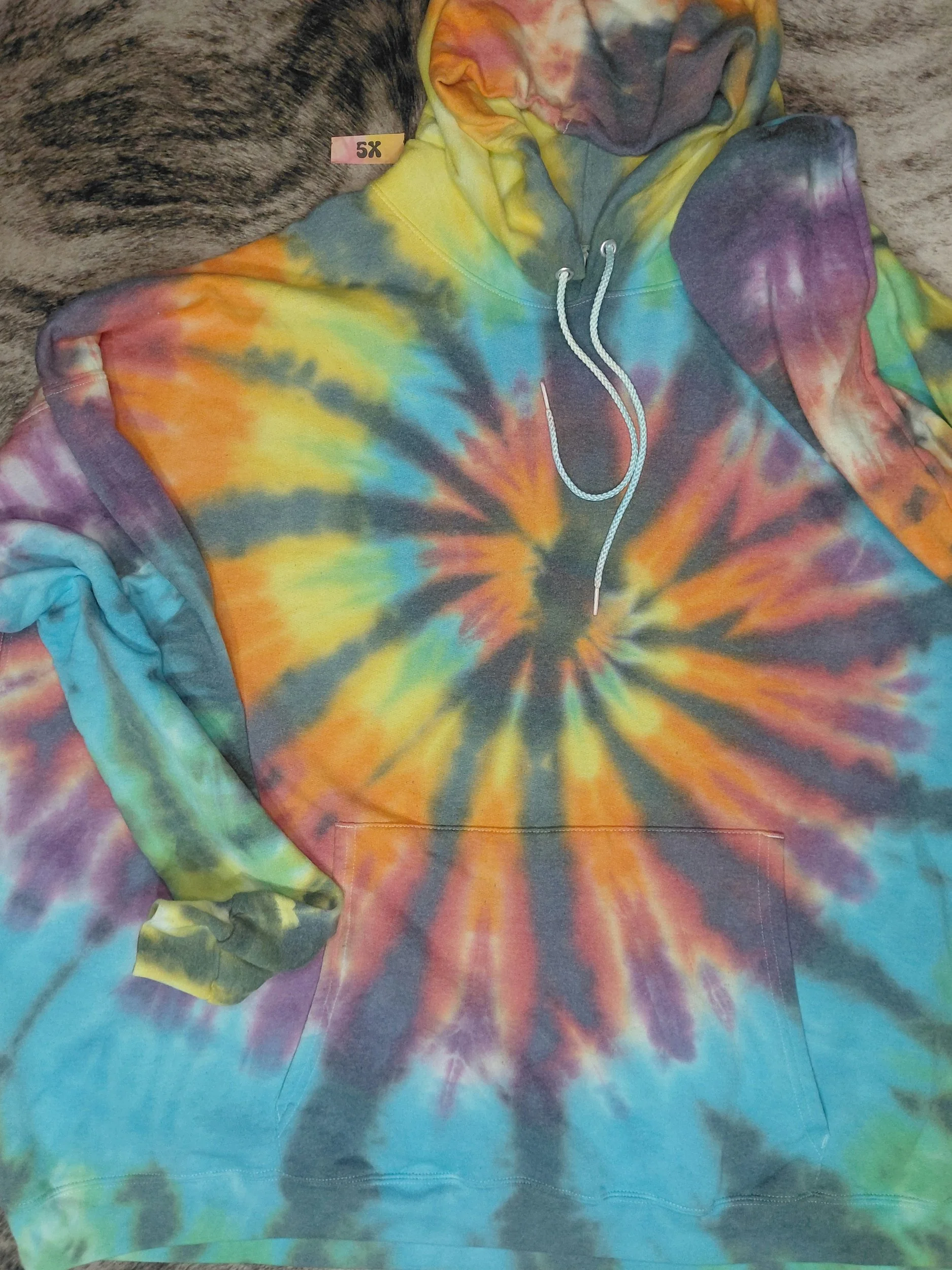 Colorful tie-dye hoodie with a spiral pattern, front pocket, and drawstrings