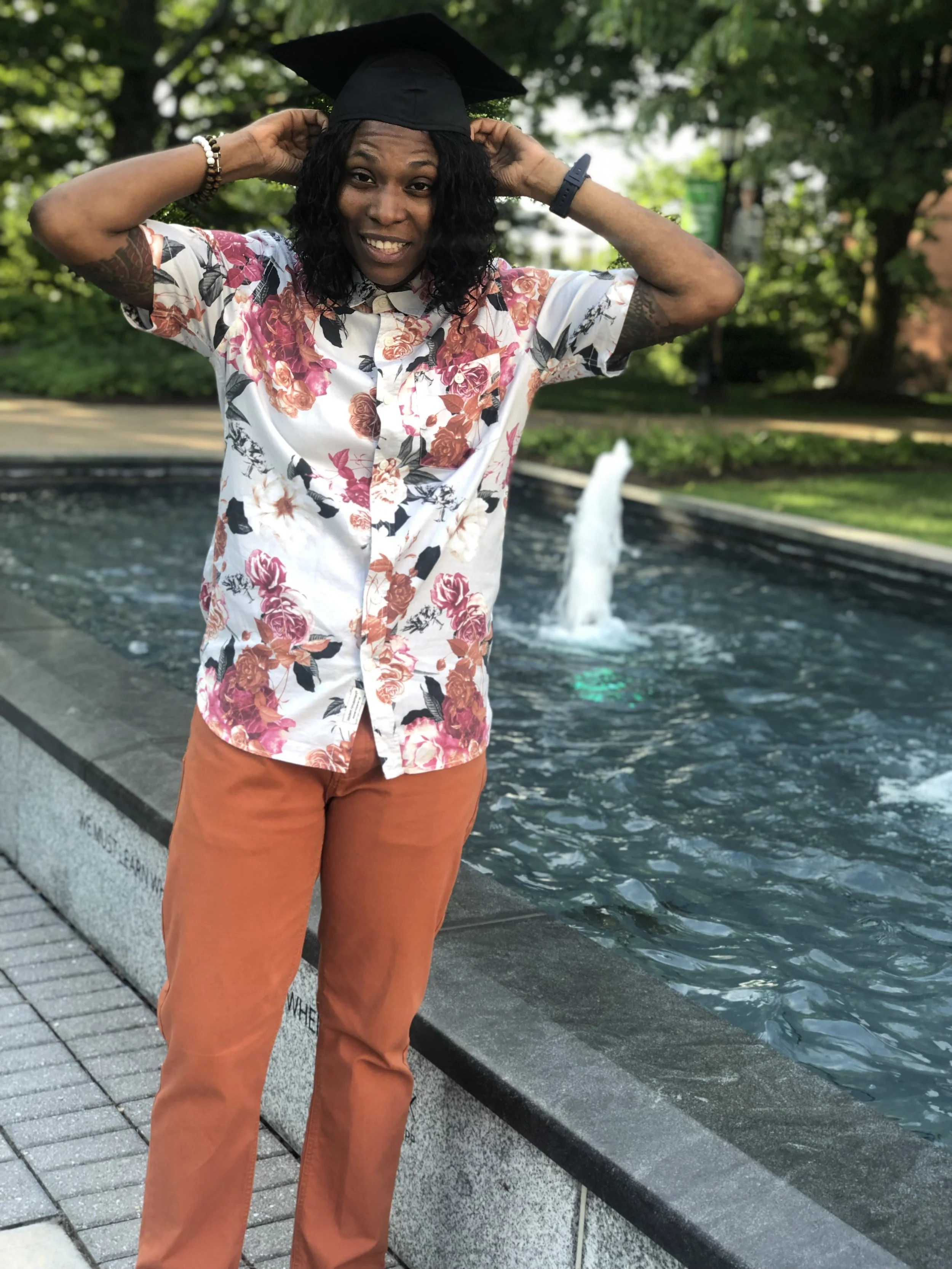 Black female adjusting graduation cap