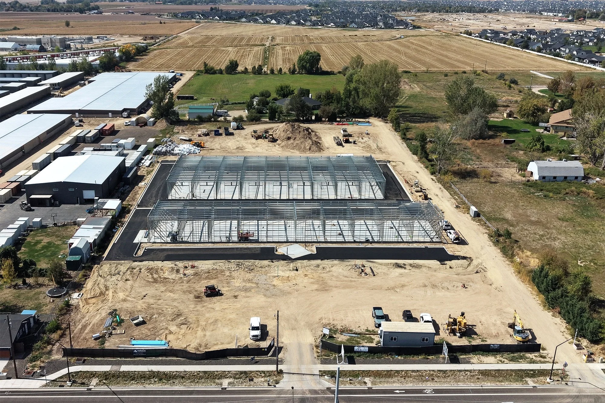 Aerial drone photo of the Ten Mile Storage Condos construction site on September 1, 2026 showing graded pads, foundations, structural steel and the site fronting N Ten Mile Road with the North Meridian growth corridor beyond