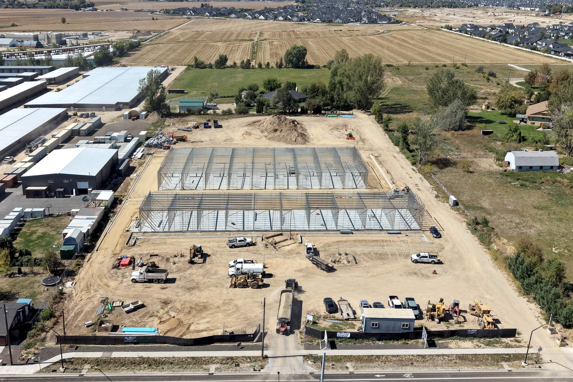 Aerial drone photo of the Ten Mile Storage Condos construction site on September 1, 2026 showing graded pads, foundations, structural steel and the site fronting N Ten Mile Road with the North Meridian growth corridor beyond