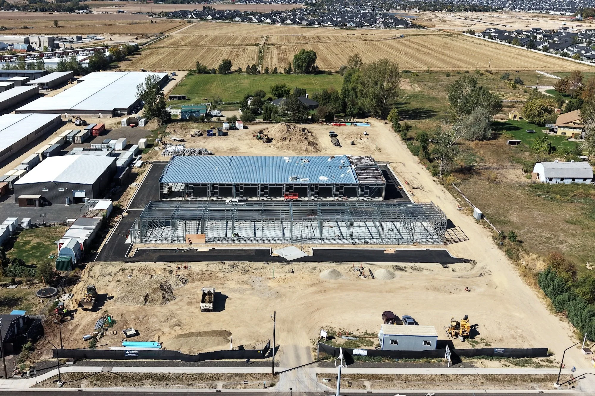 Aerial drone photo of the Ten Mile Storage Condos construction site on September 1, 2026 showing graded pads, foundations, structural steel and the site fronting N Ten Mile Road with the North Meridian growth corridor beyond