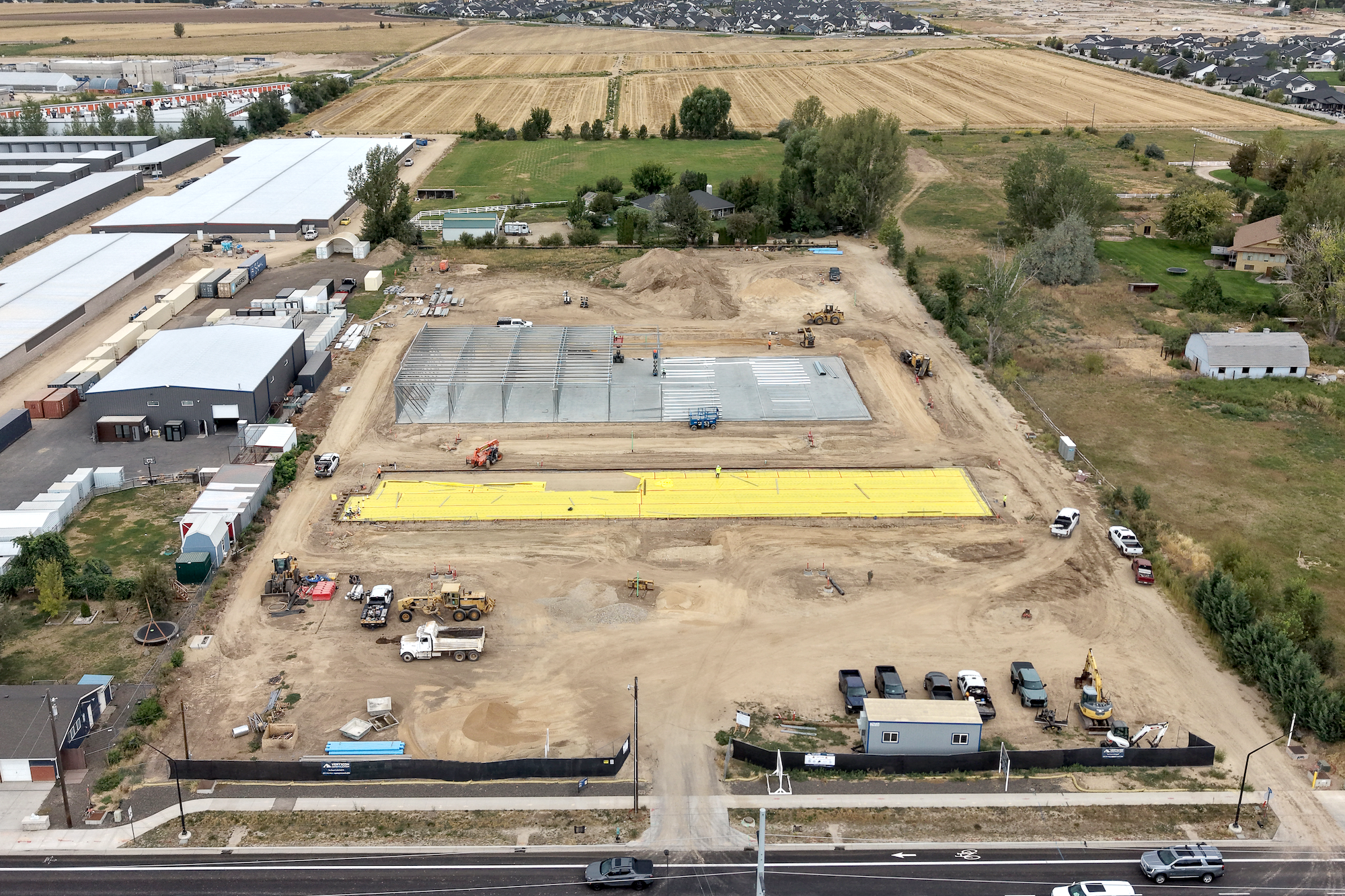 Aerial drone photo of the Ten Mile Storage Condos construction site on September 1, 2026 showing graded pads, foundations, structural steel and the site fronting N Ten Mile Road with the North Meridian growth corridor beyond