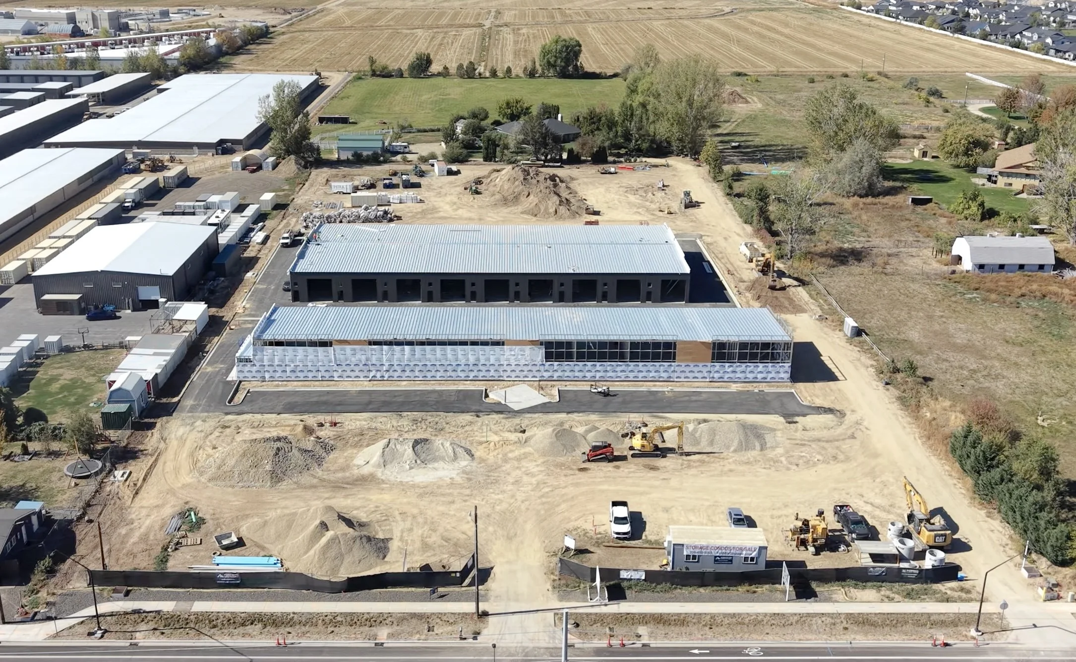 Aerial drone photo of the Ten Mile Storage Condos construction site on September 1, 2026 showing graded pads, foundations, structural steel and the site fronting N Ten Mile Road with the North Meridian growth corridor beyond