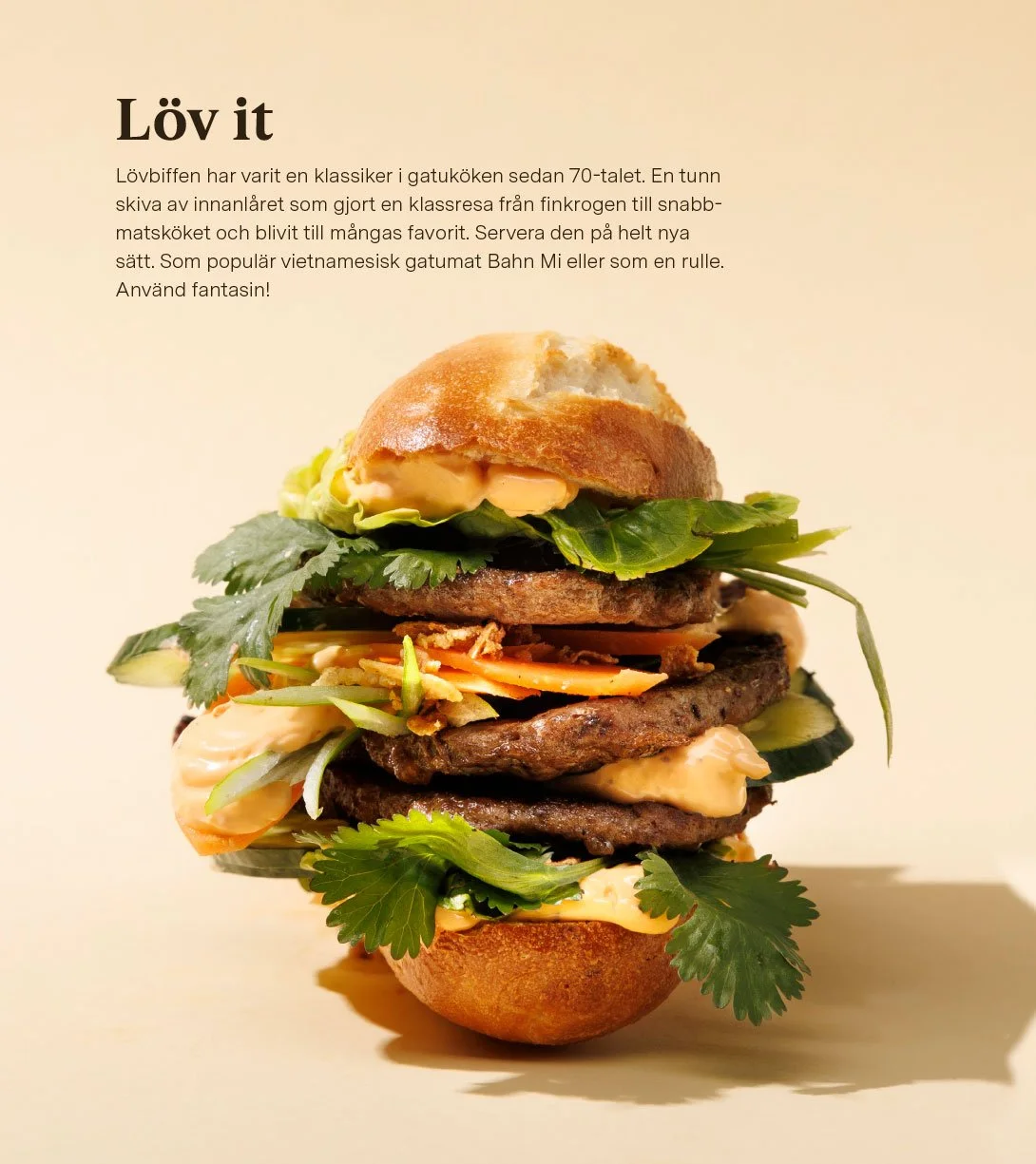 A tall Vietnamese banh mi sandwich with bread, leafy greens, sliced vegetables, grilled meat, and herbs.