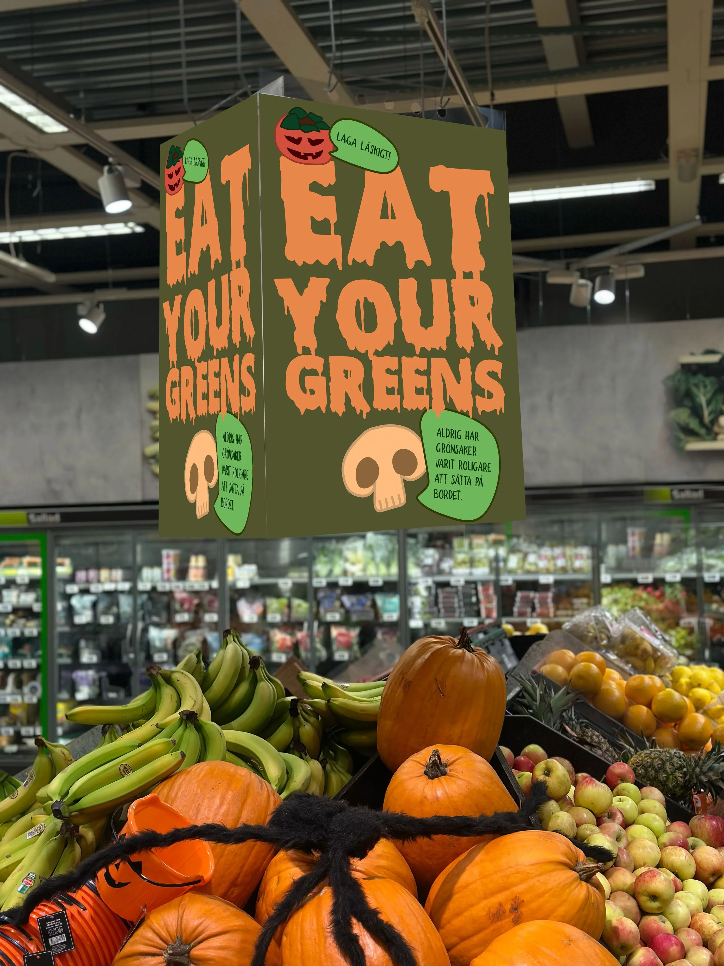 Display of pumpkins, bananas, apples, and other fruits at a grocery store with Halloween decorations and signs.