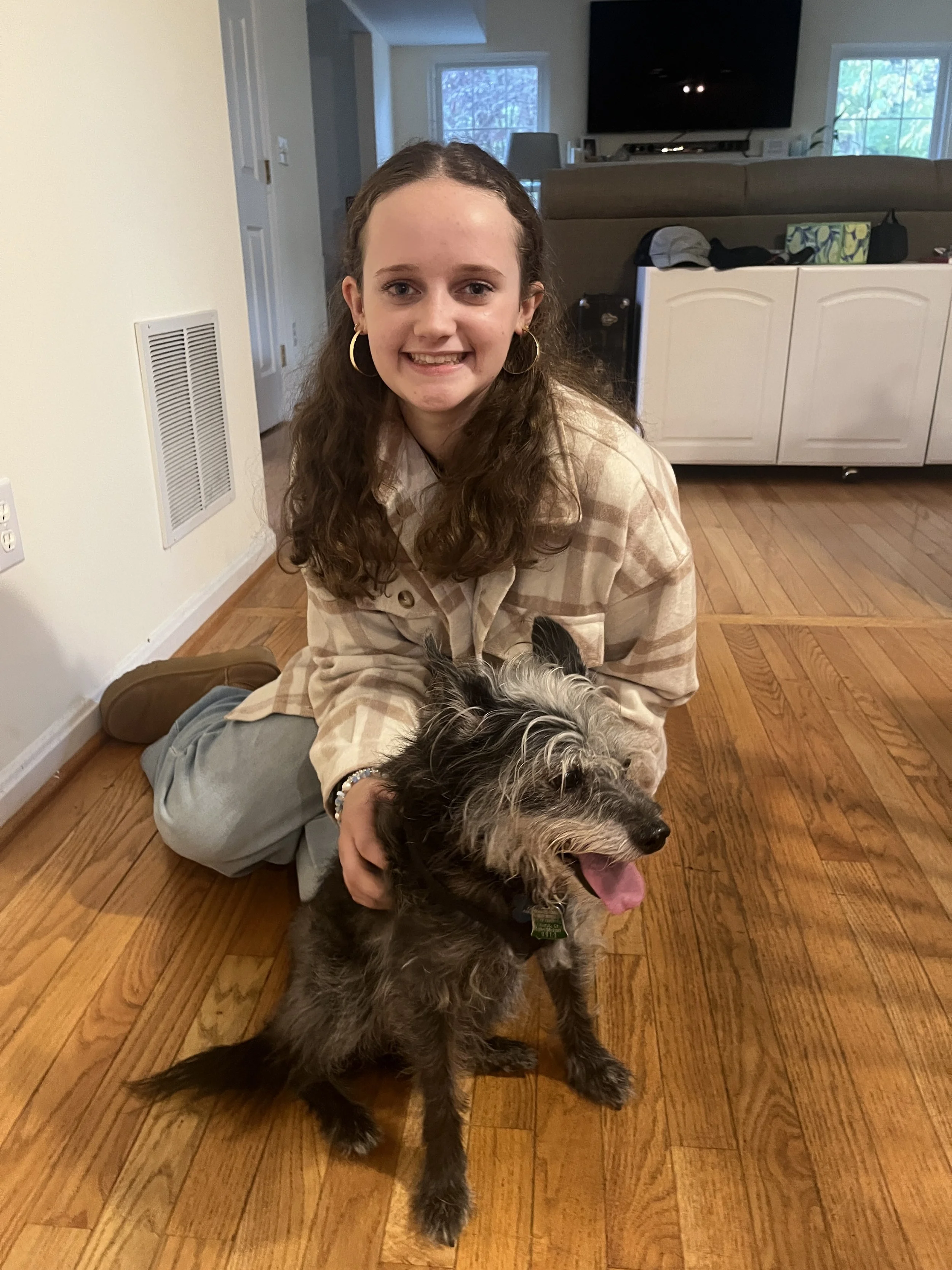Janie sitting on the floor petting her dog